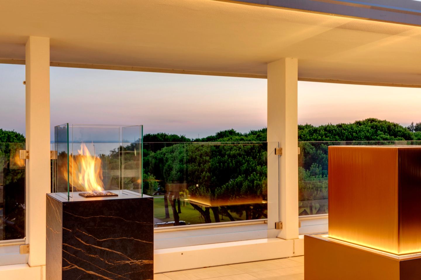 Flame standing in the marble column, pines beyond