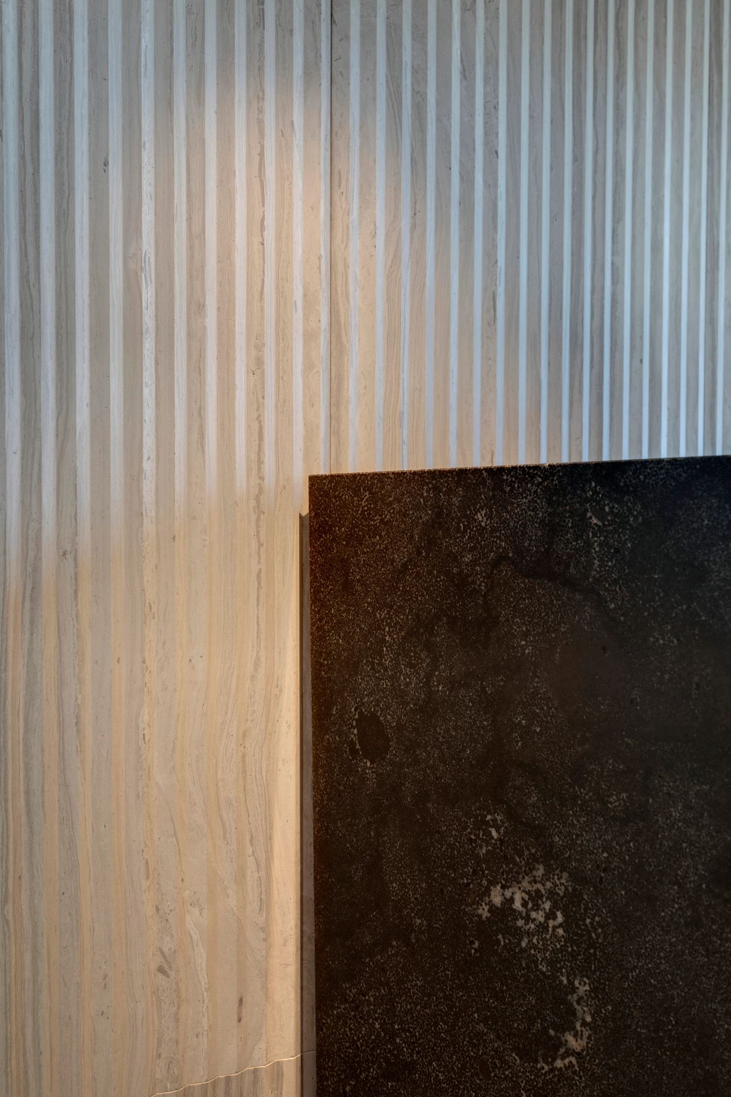 Two stones meeting: fluted pale and honed dark