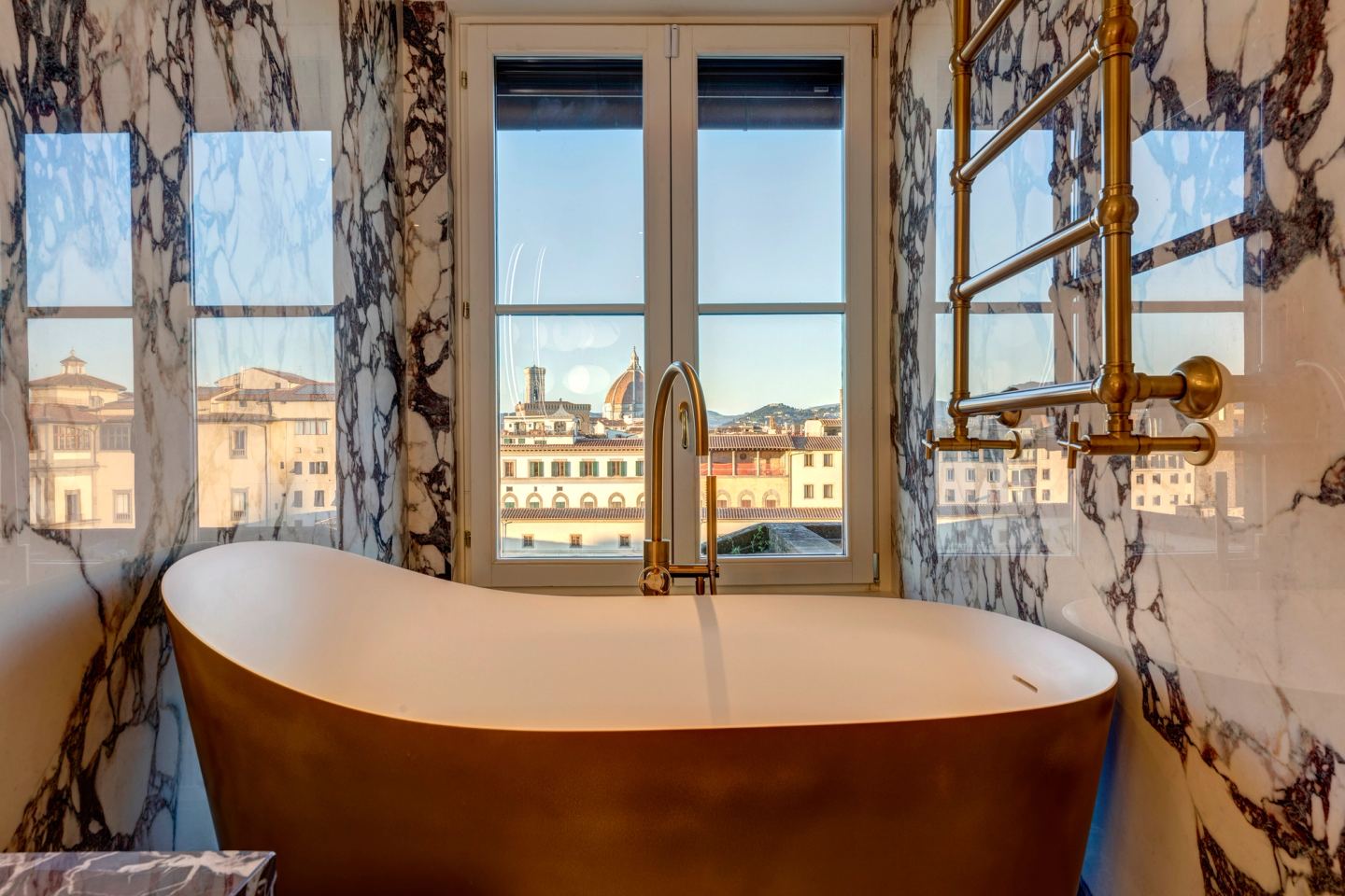 The brass bath standing free in the marble room