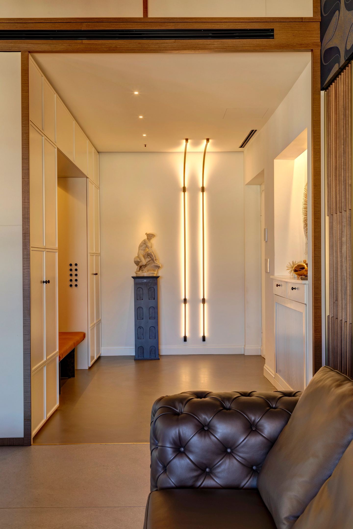 Bench, sculpture and the run of doors beyond