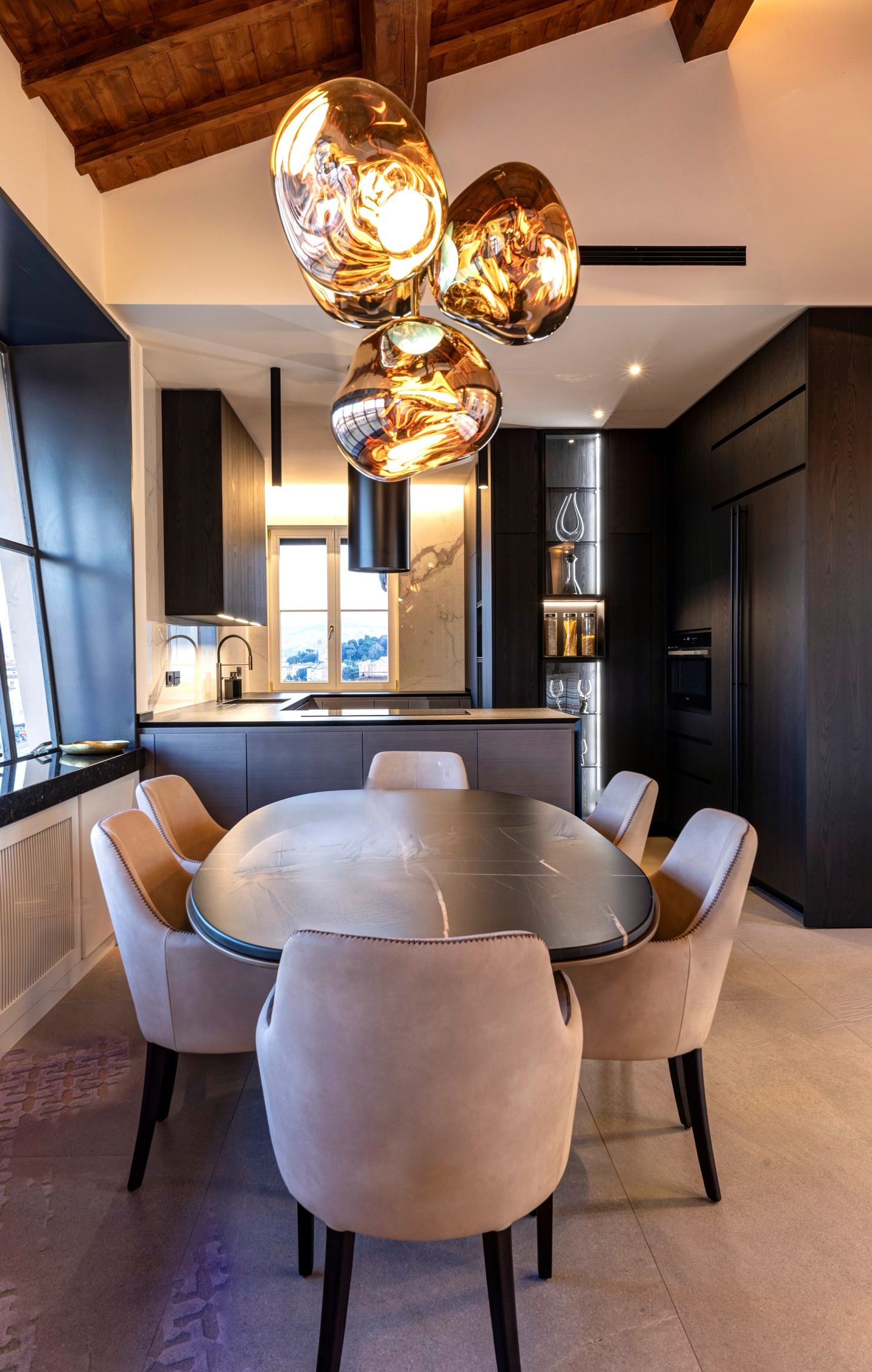The table and chairs with the kitchen open behind