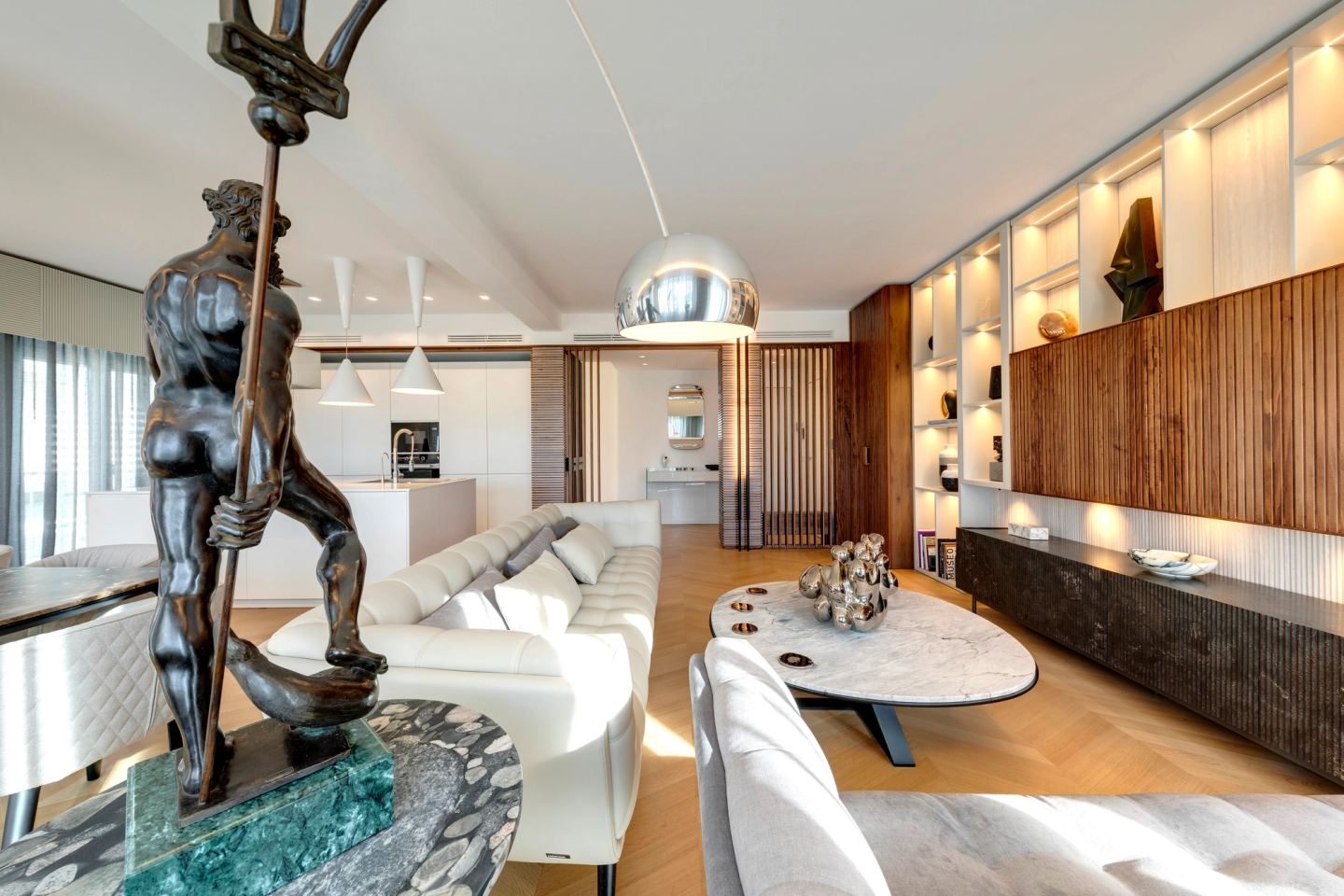 Long view across the living room to the kitchen, sculpture at the near edge