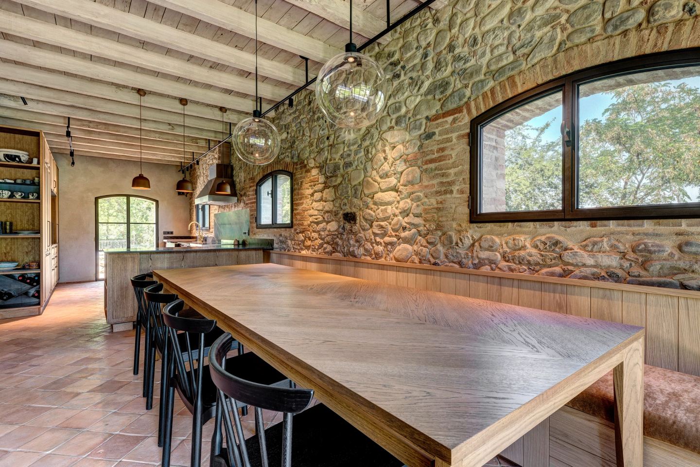 The long table, black stools, glass globes above