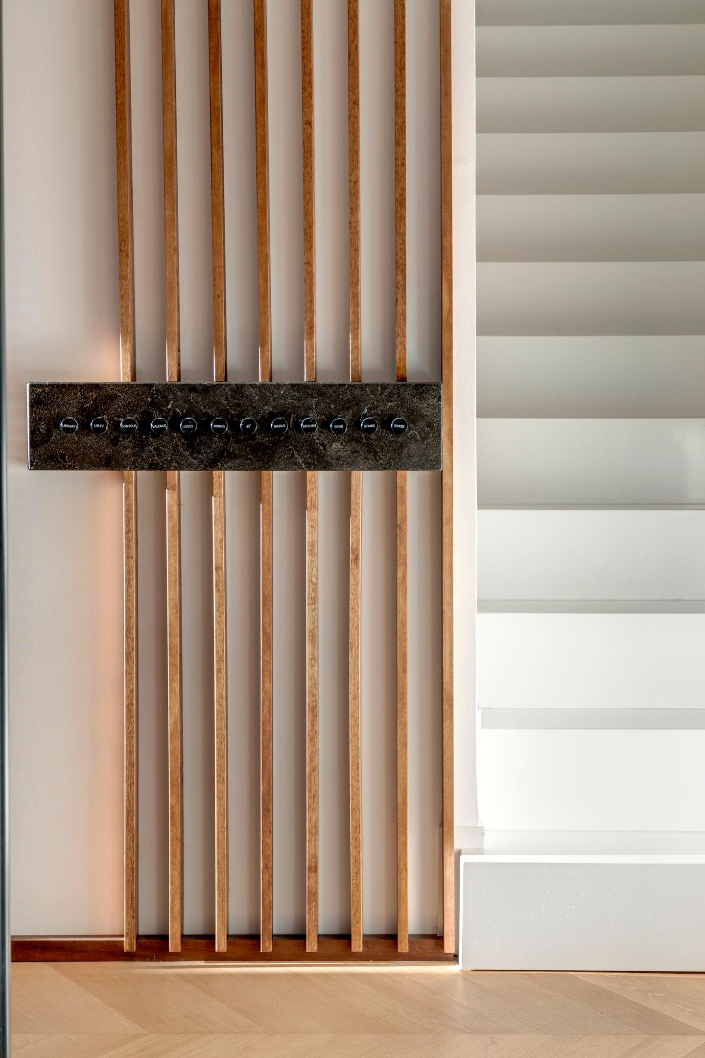 Brass switch plate set into the walnut slats