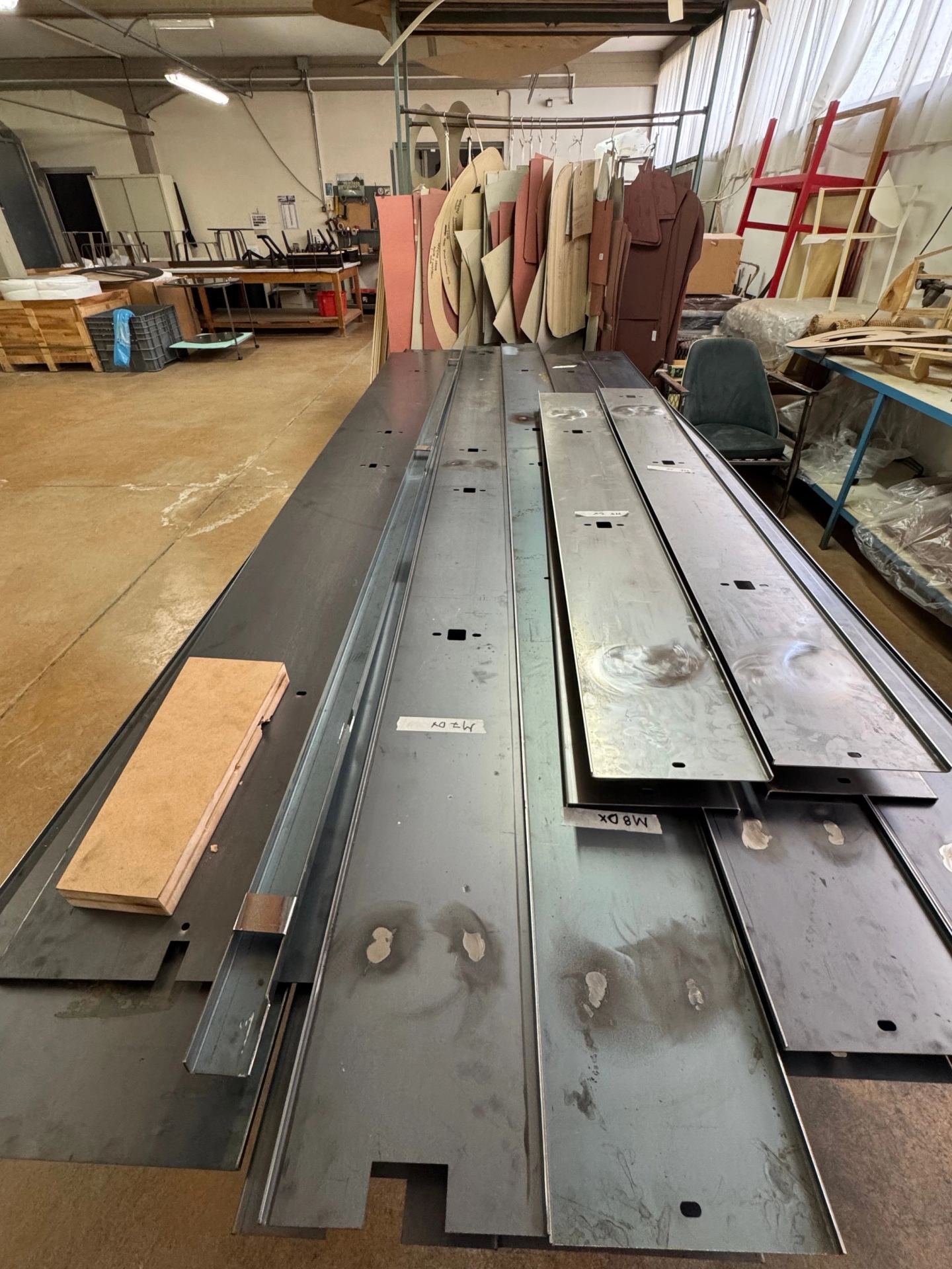 Metal profiles for the library laid out on the workshop floor