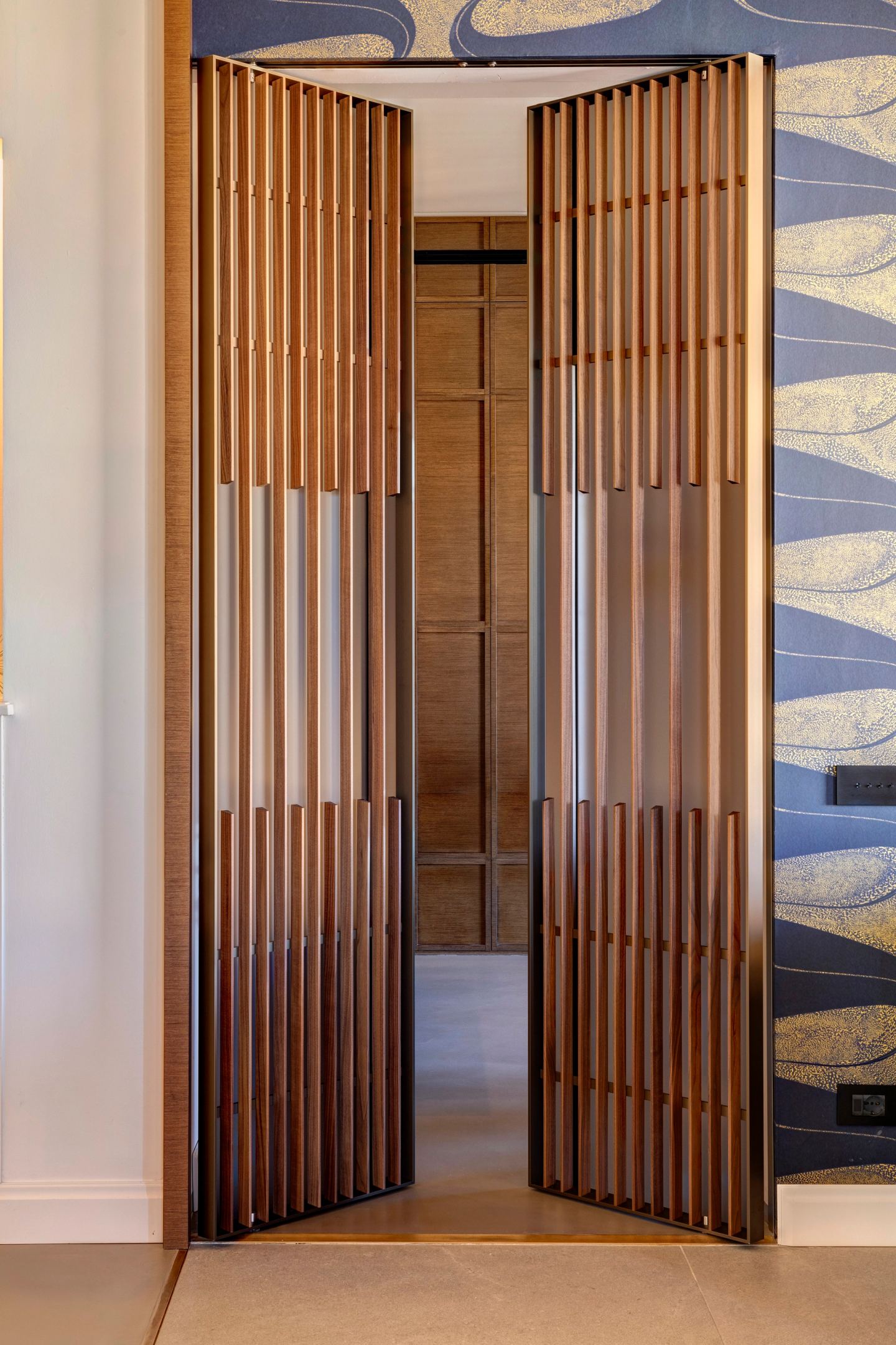 The door half open, light passing between the slats