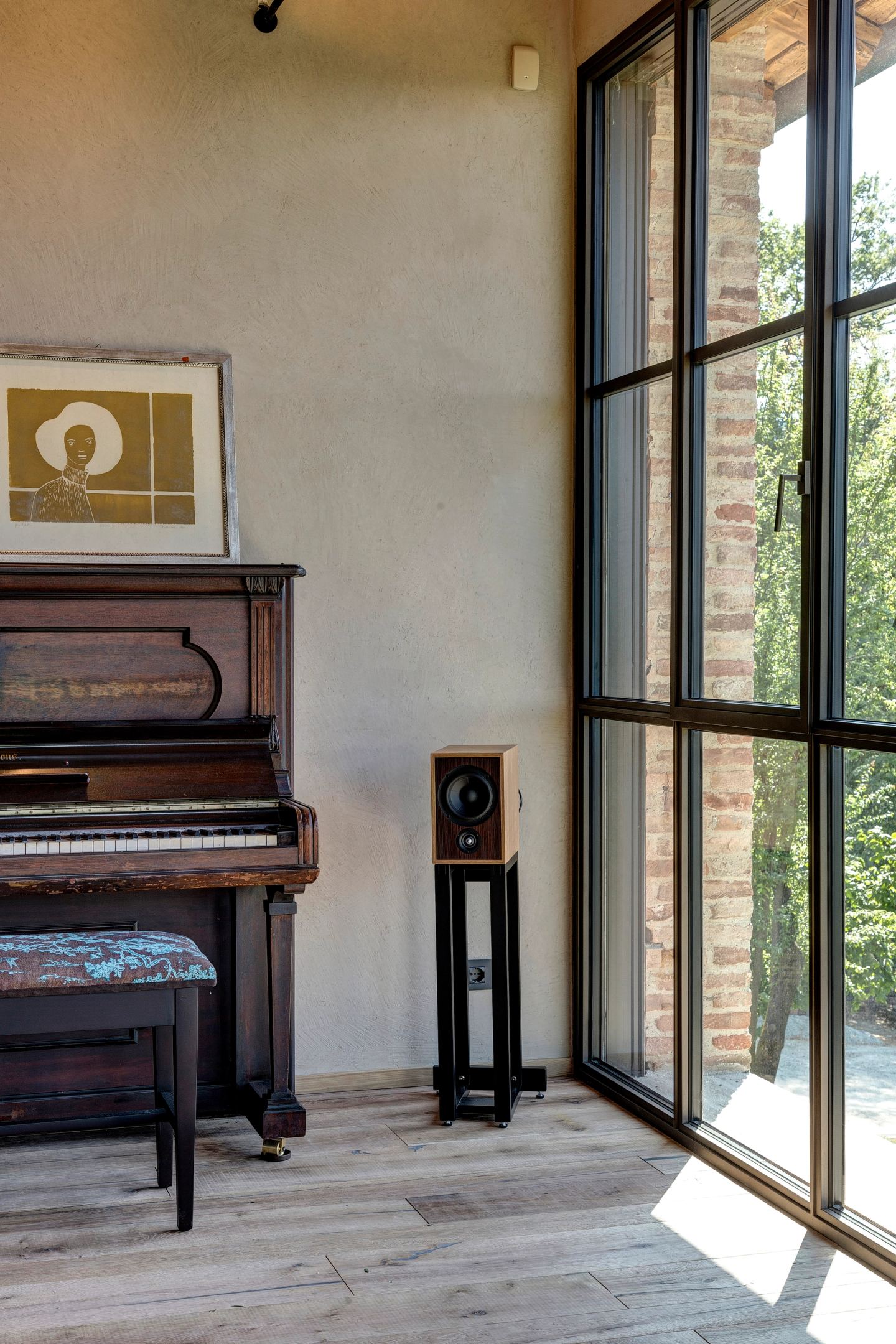 The upright piano between the windows