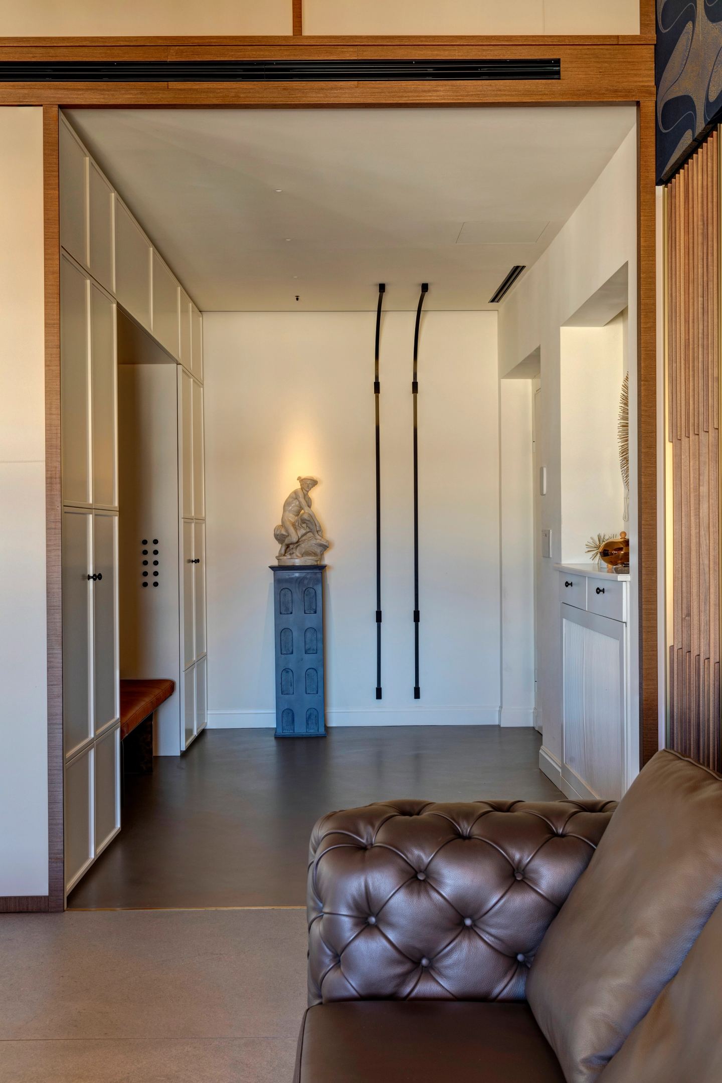 The entrance hall, a sculpture on its plinth lit from the track above