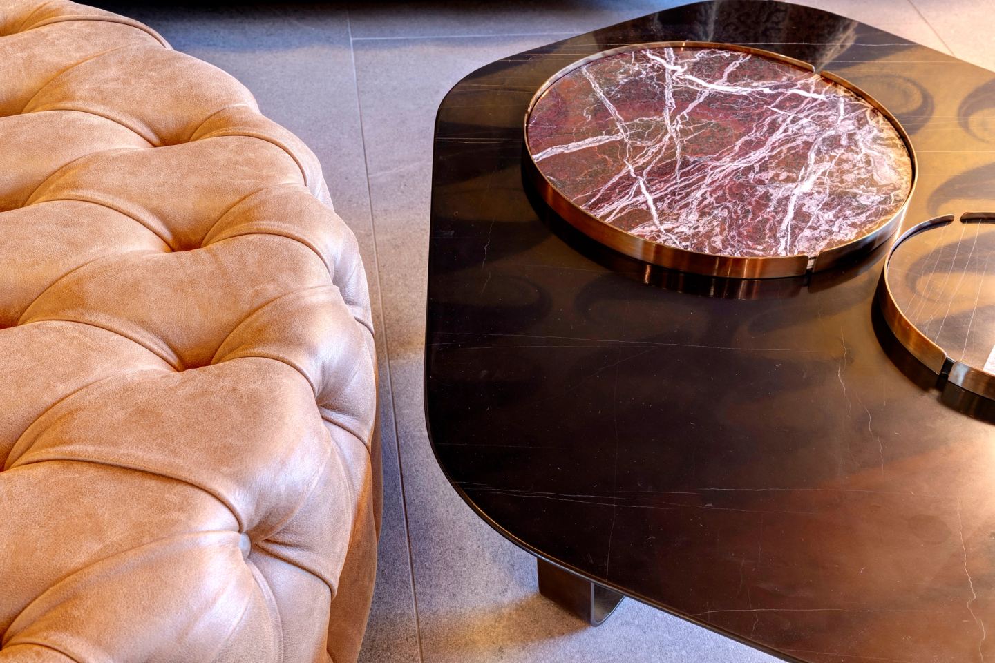 The tufted ottoman and the red marble table, close