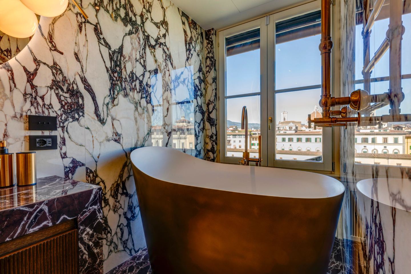 Marble, brass and daylight across the bath