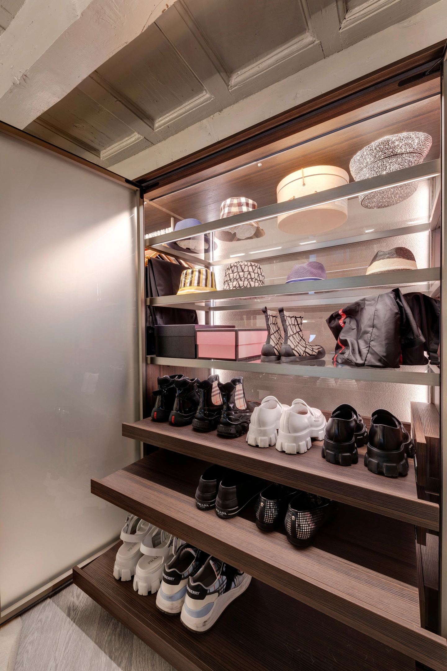 I ripiani illuminati dall'interno: cappelli in alto, scarpe in basso
