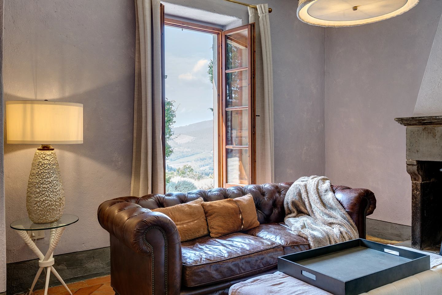 The chesterfield under the lamp, window to the fields