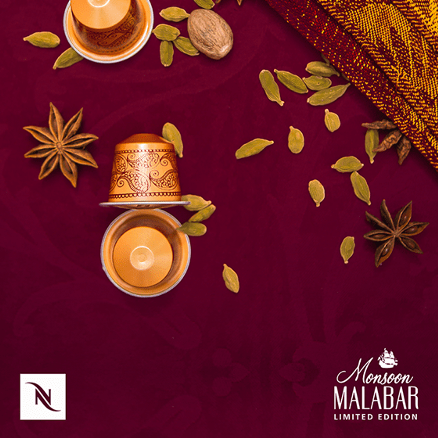 Nespresso Monsoon Malabar capsules on maroon cloth with star anise and cardamom pods