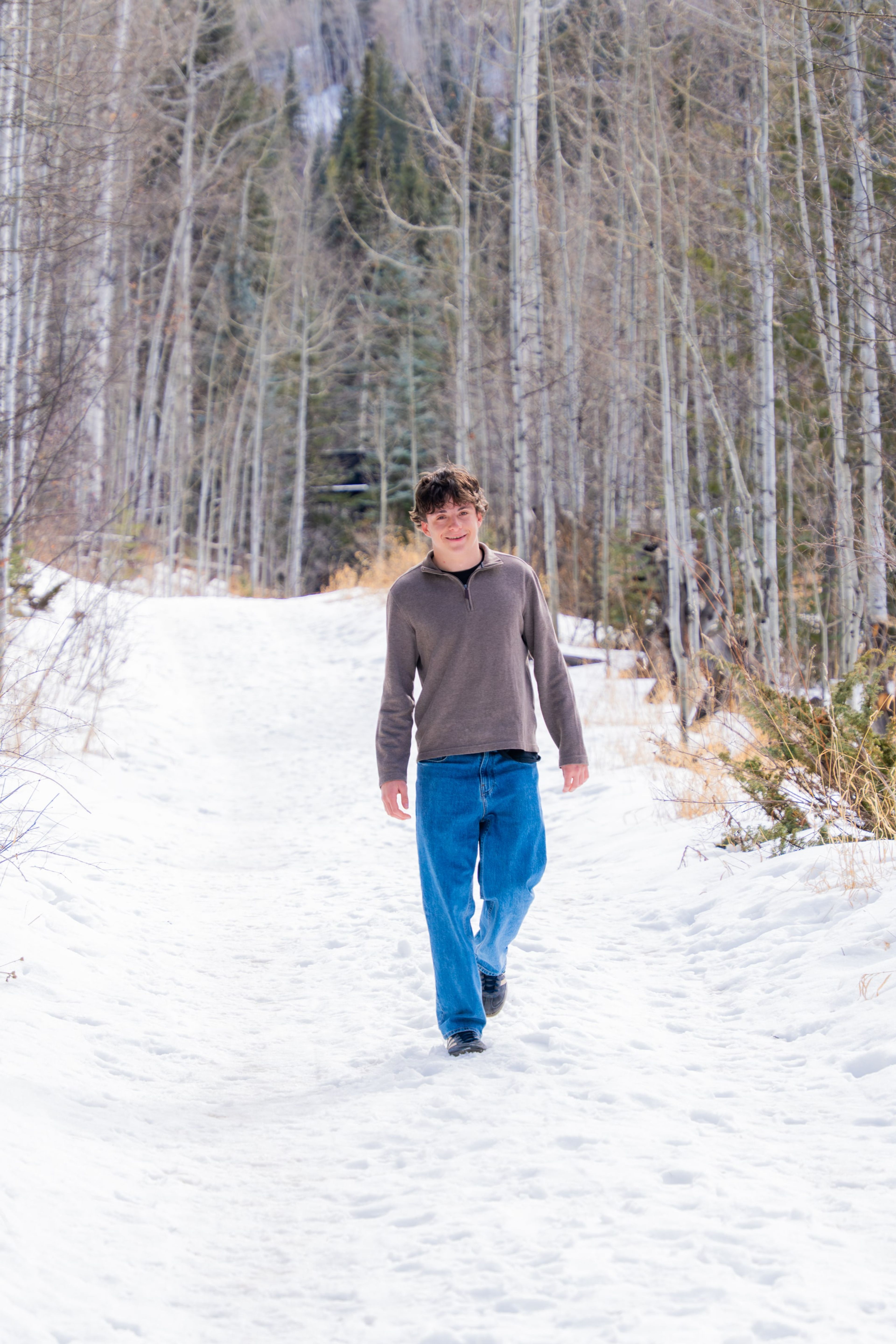 Luca walking a slushy creek path in bright snow