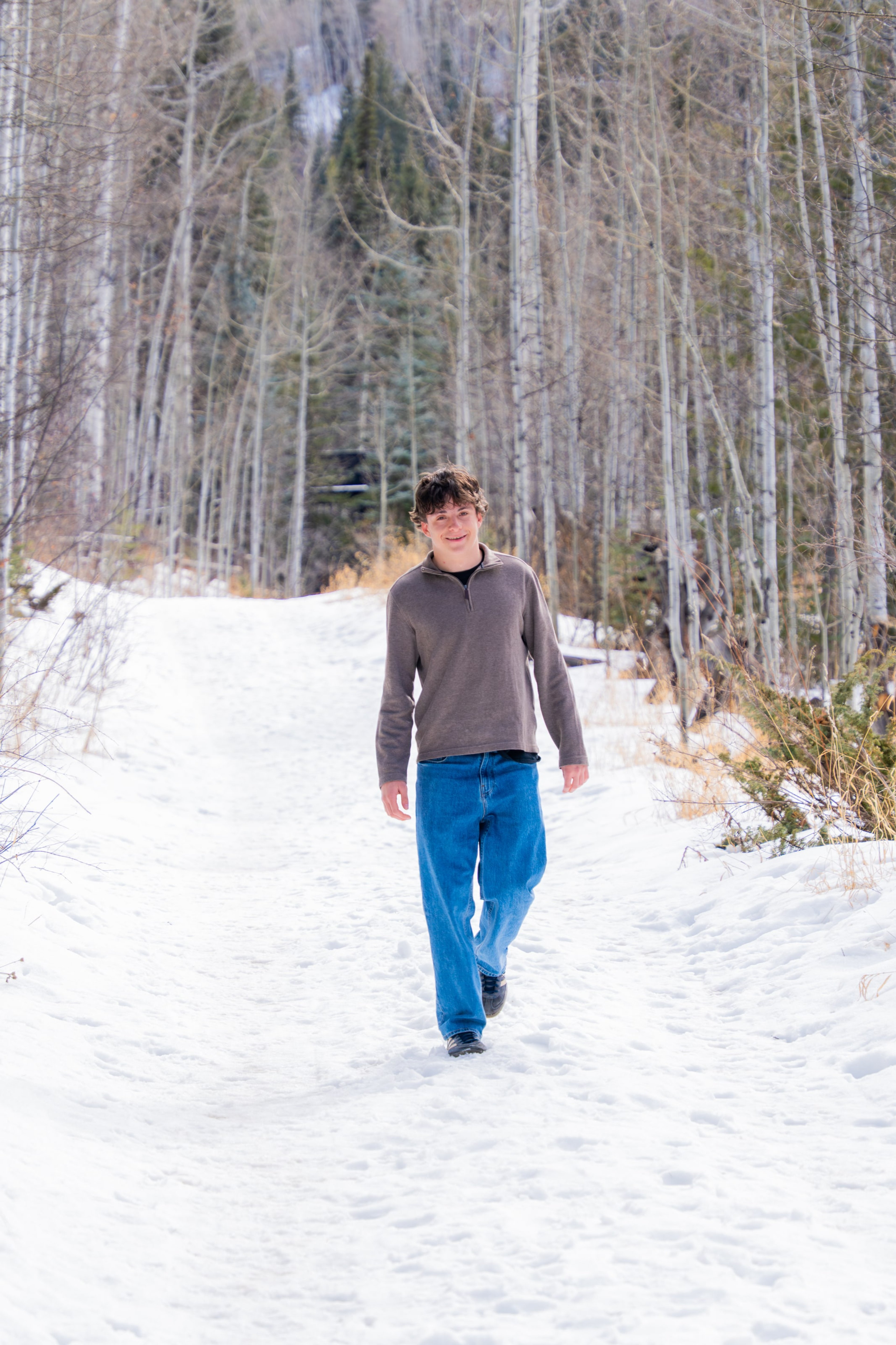 Luca walking a slushy creek path in bright snow