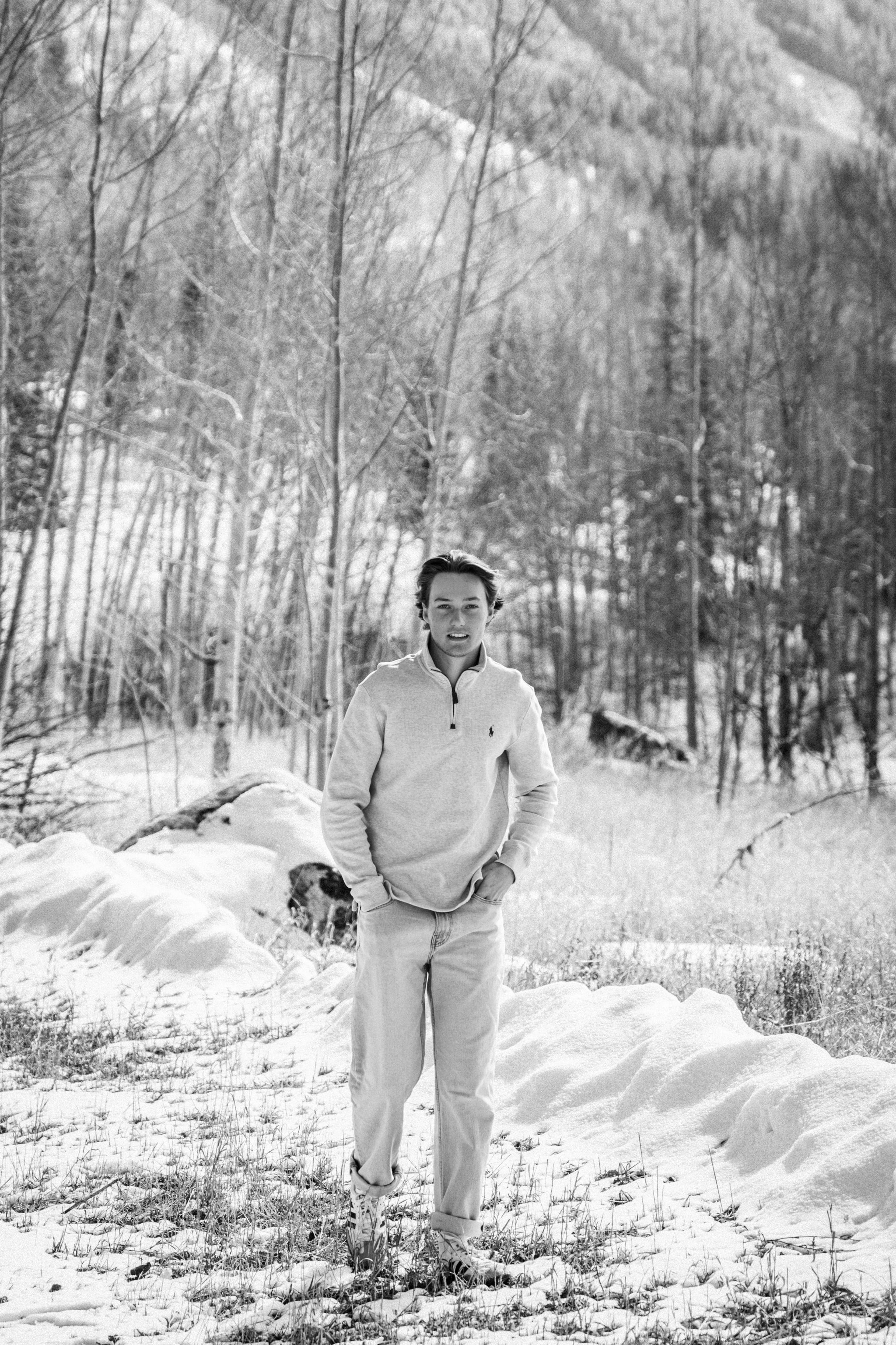 Caeden walking through a bright snow-blown aspen stand