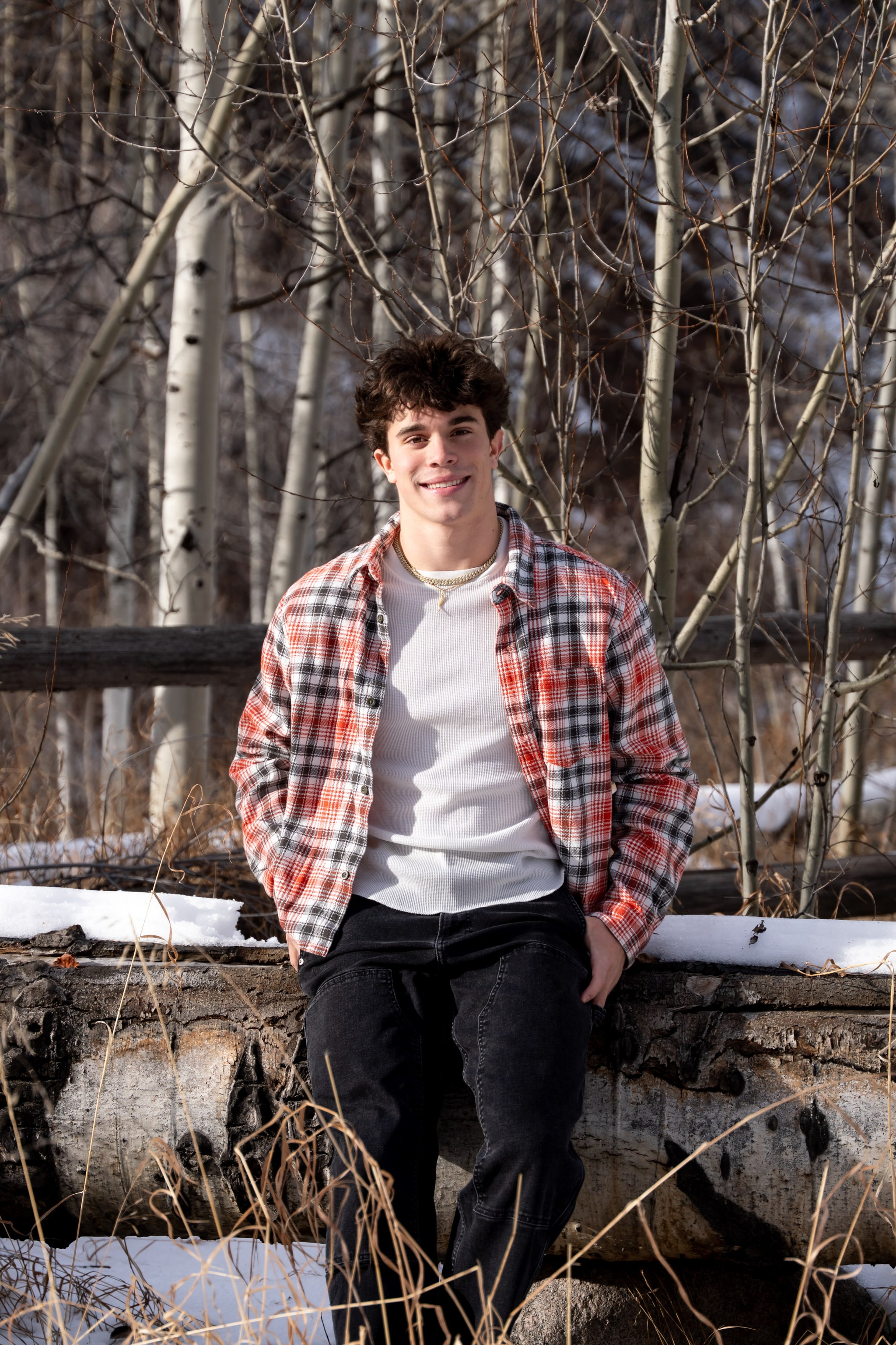 Ryder seated among the winter aspens, easy smile