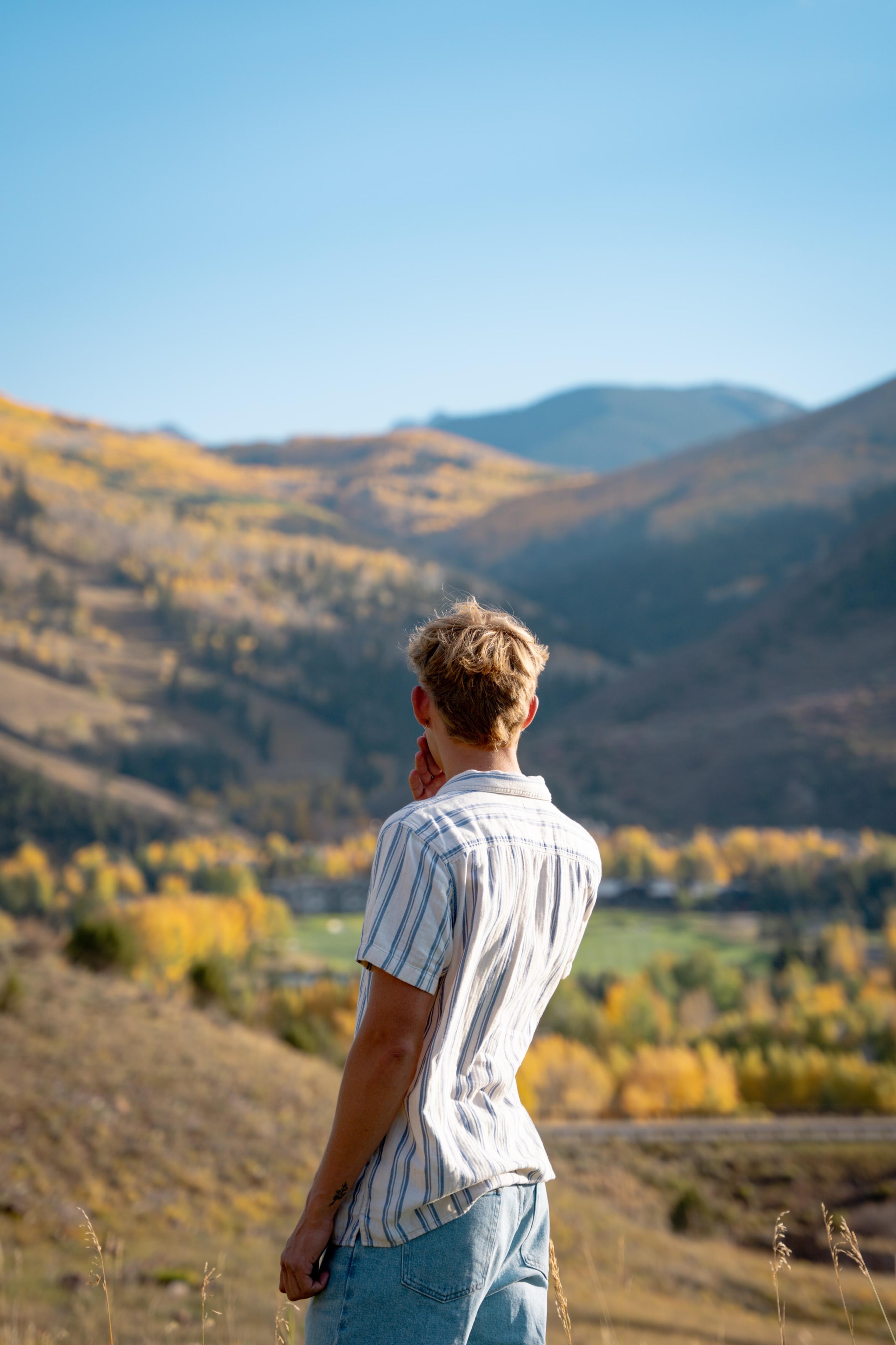 Wyat overlooking a golden aspen valley from a high ridge