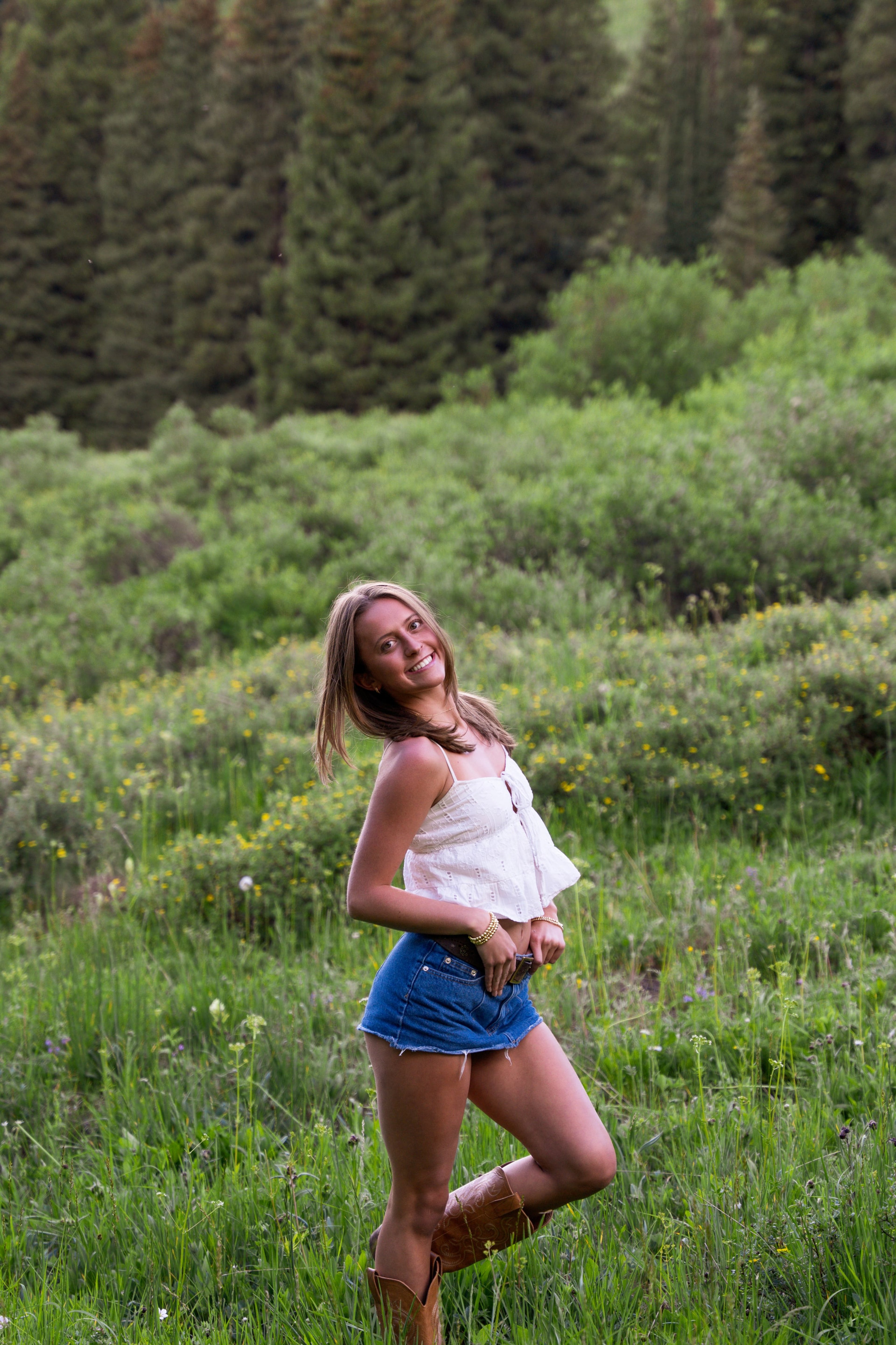 A girl in a white top posing in the wildflowers