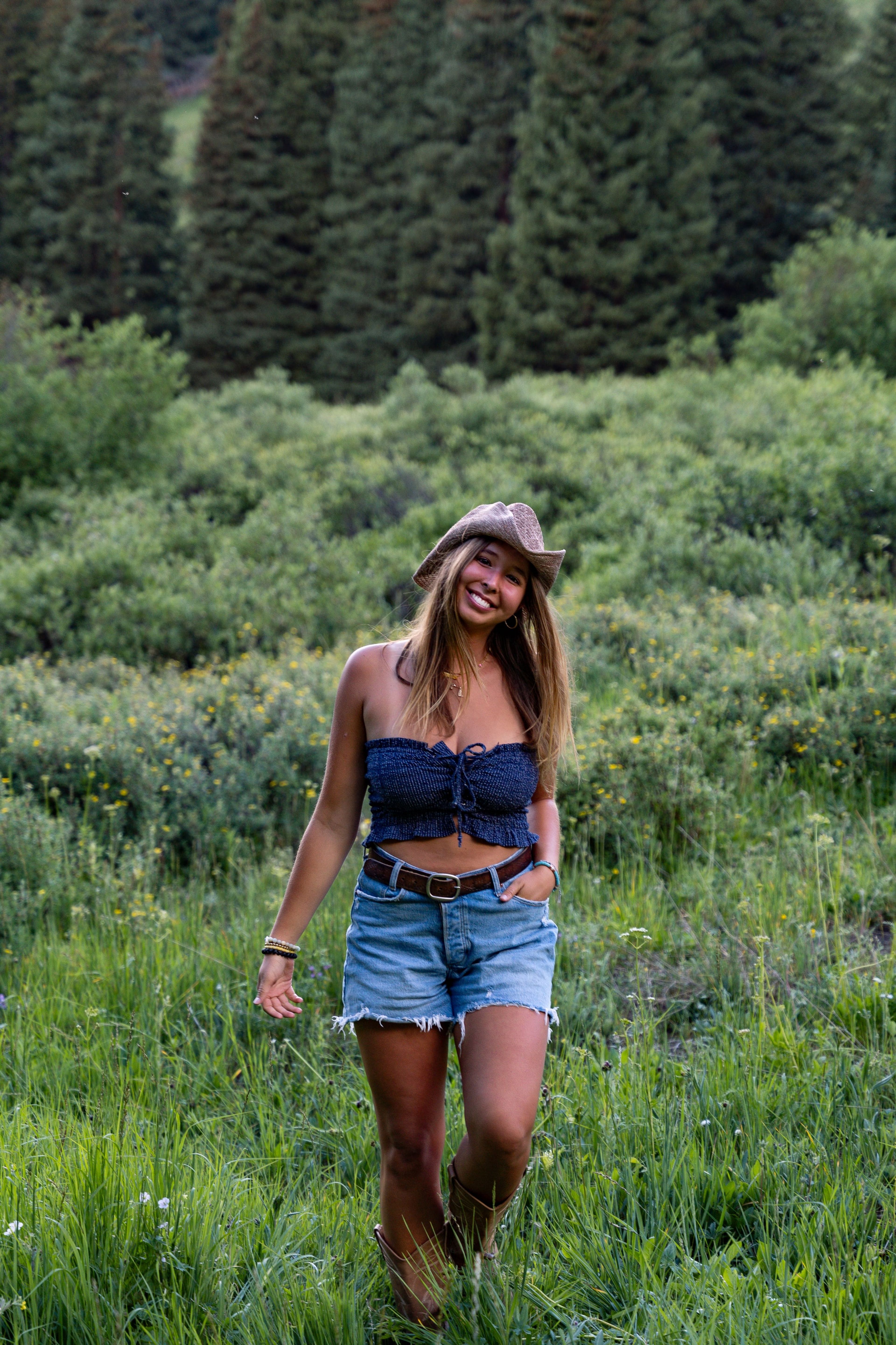 A girl walking the meadow smiling, wildflowers to her knees