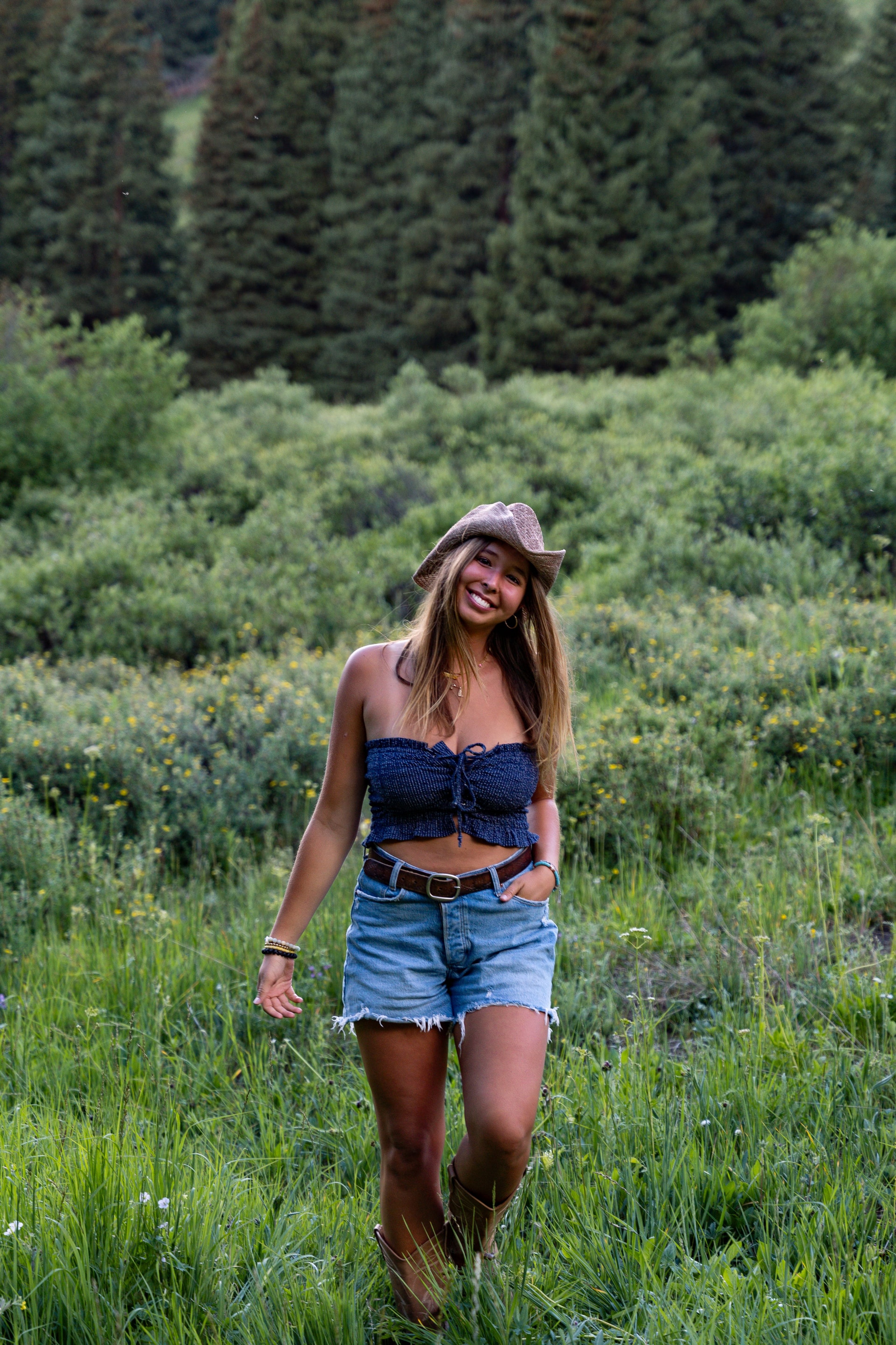 A girl walking the meadow smiling, wildflowers to her knees
