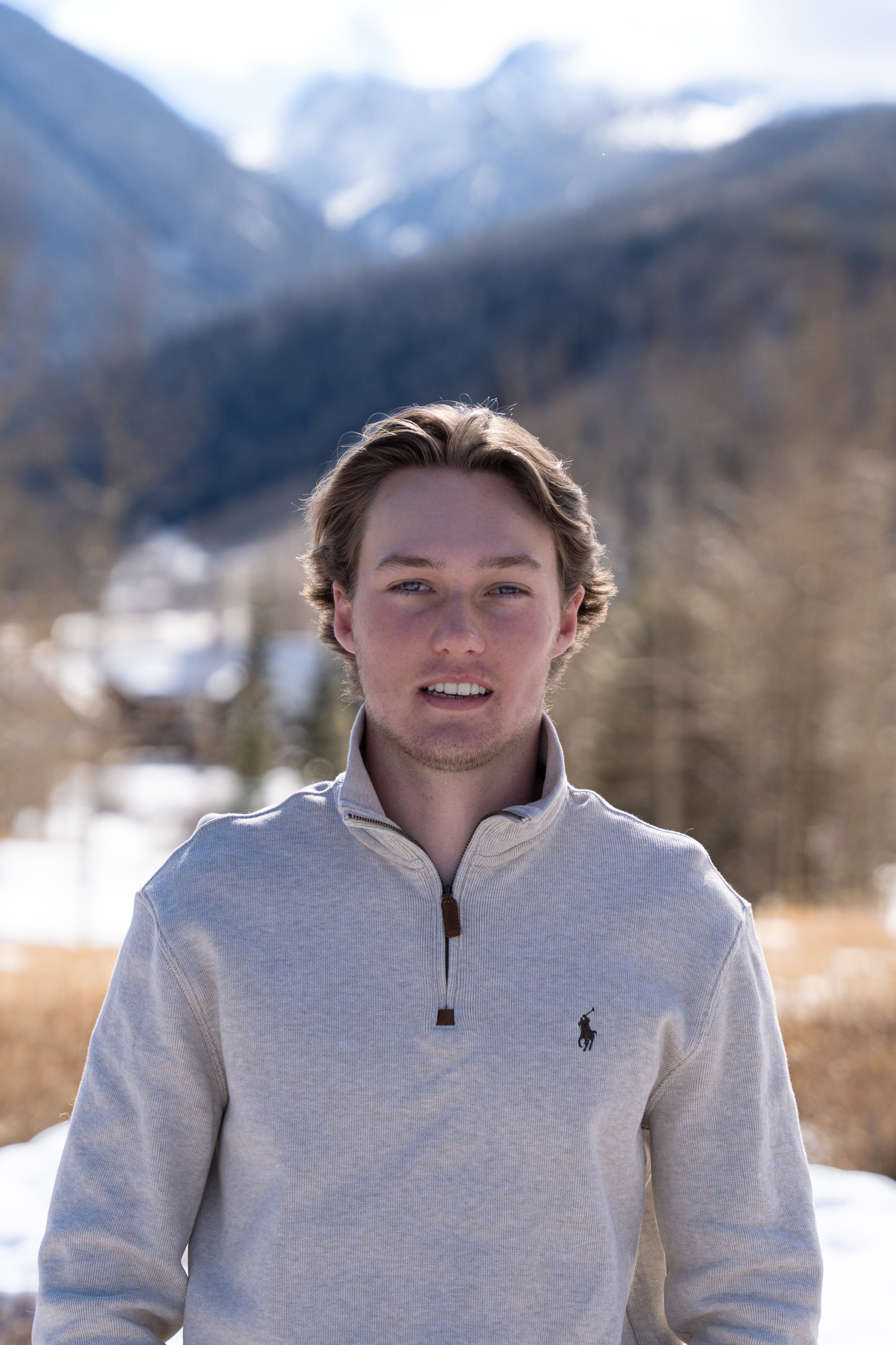 Caeden in a cream sweater smiling in front of the range