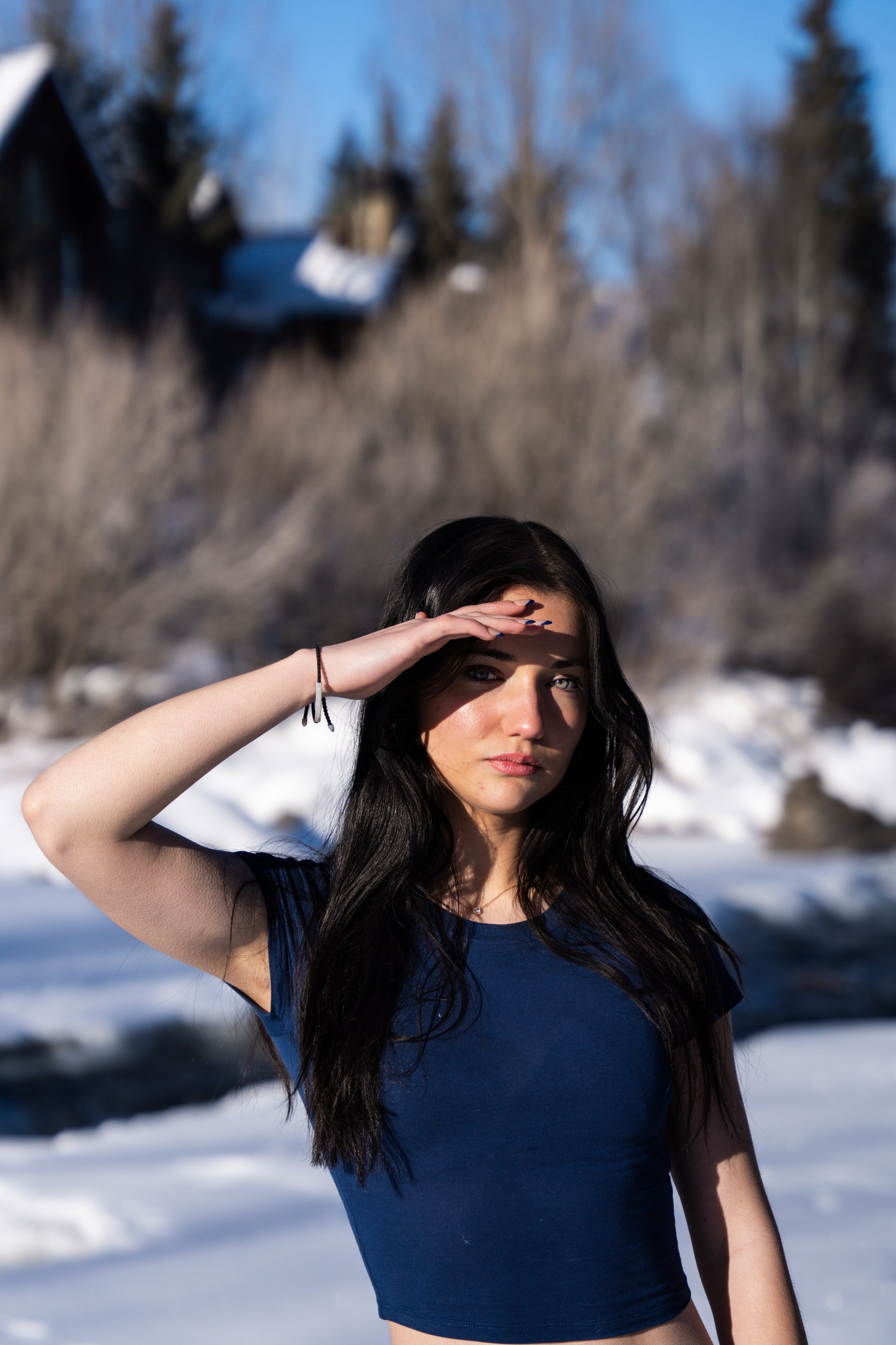 Lucy shielding her eyes from the winter sun at the river's edge