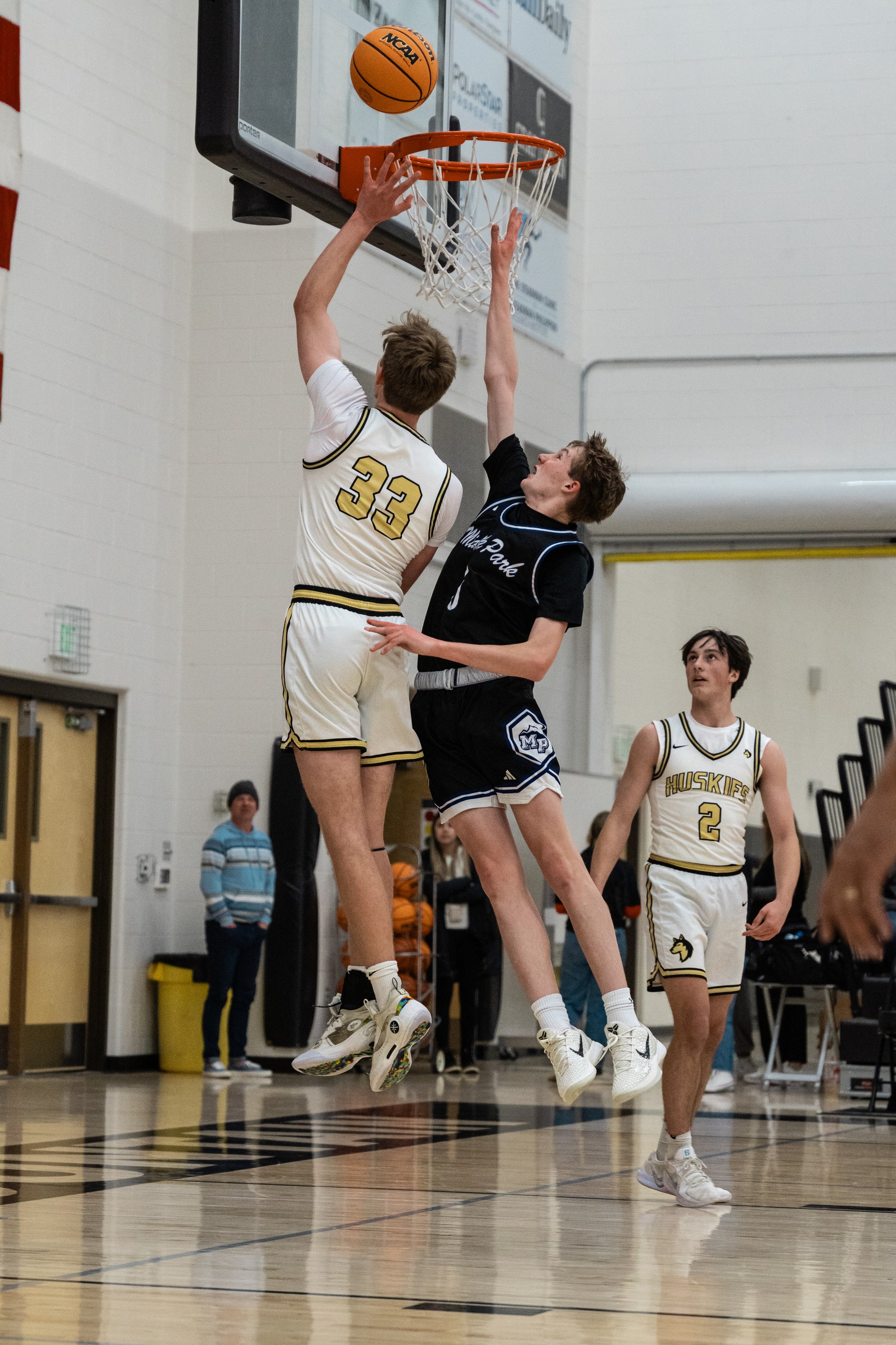 A contested finish at the rim with both players airborne