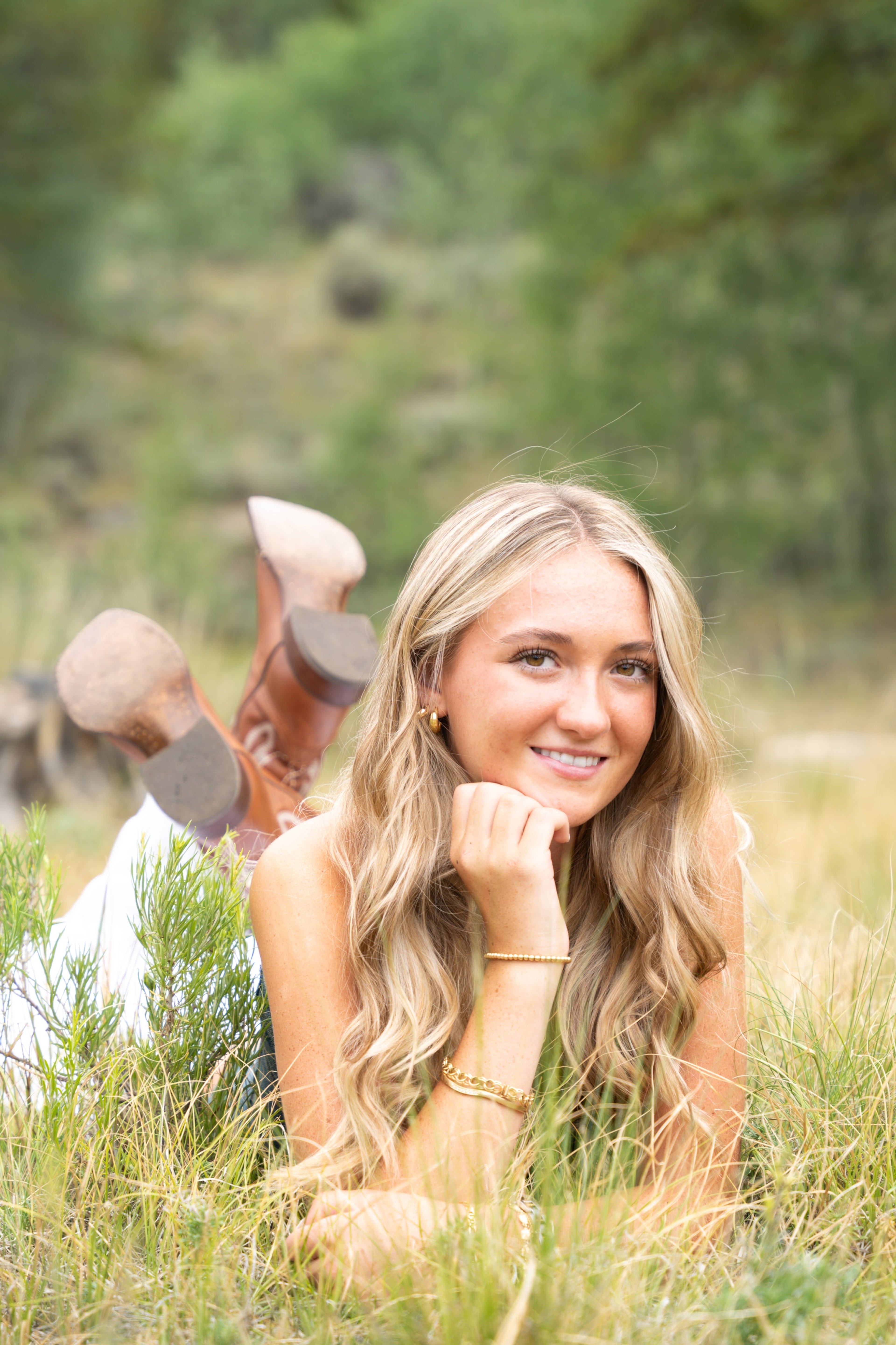 Caleigh lying in the grass with her chin resting on her hand