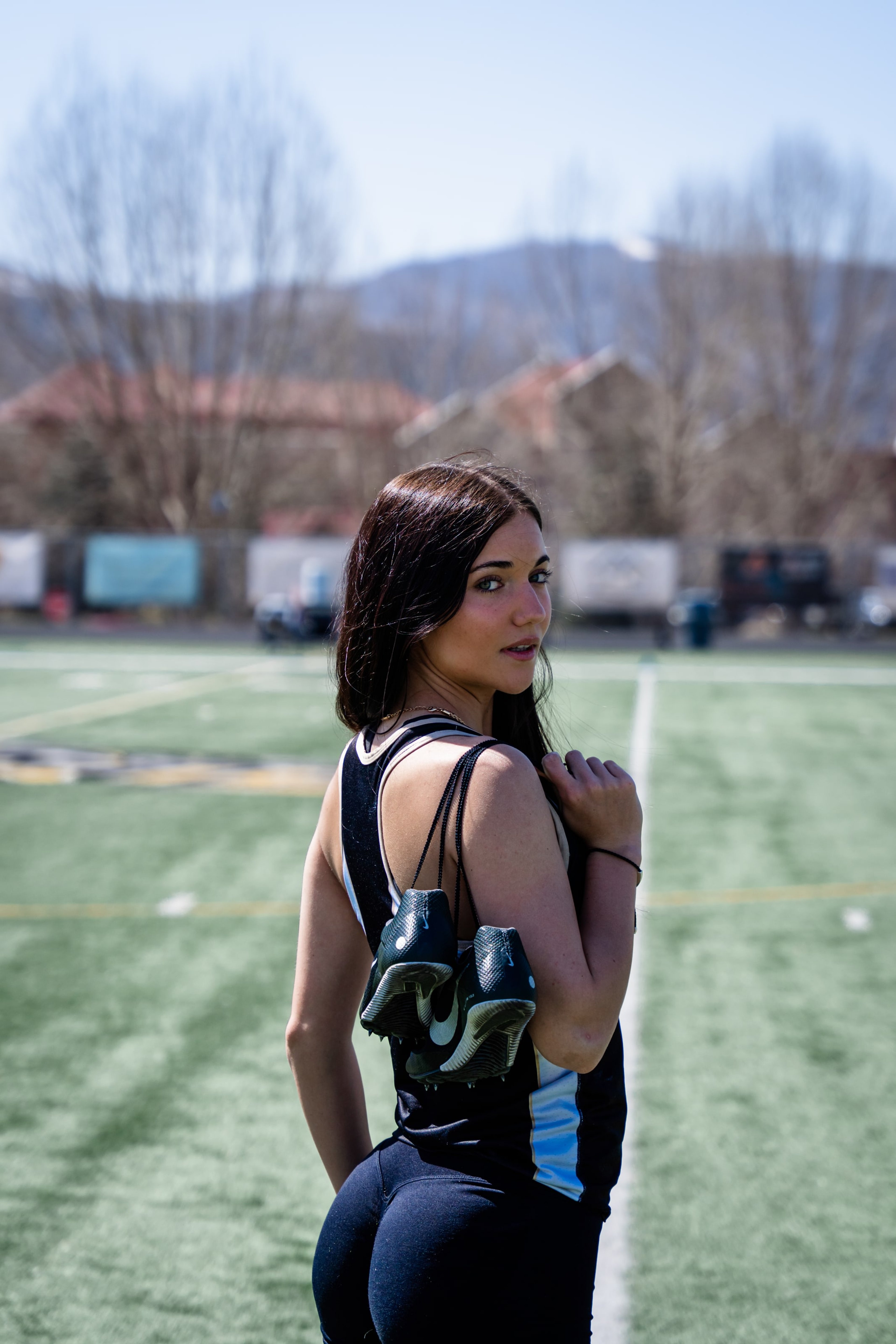 Lucy from behind in her race kit, mountains over the field