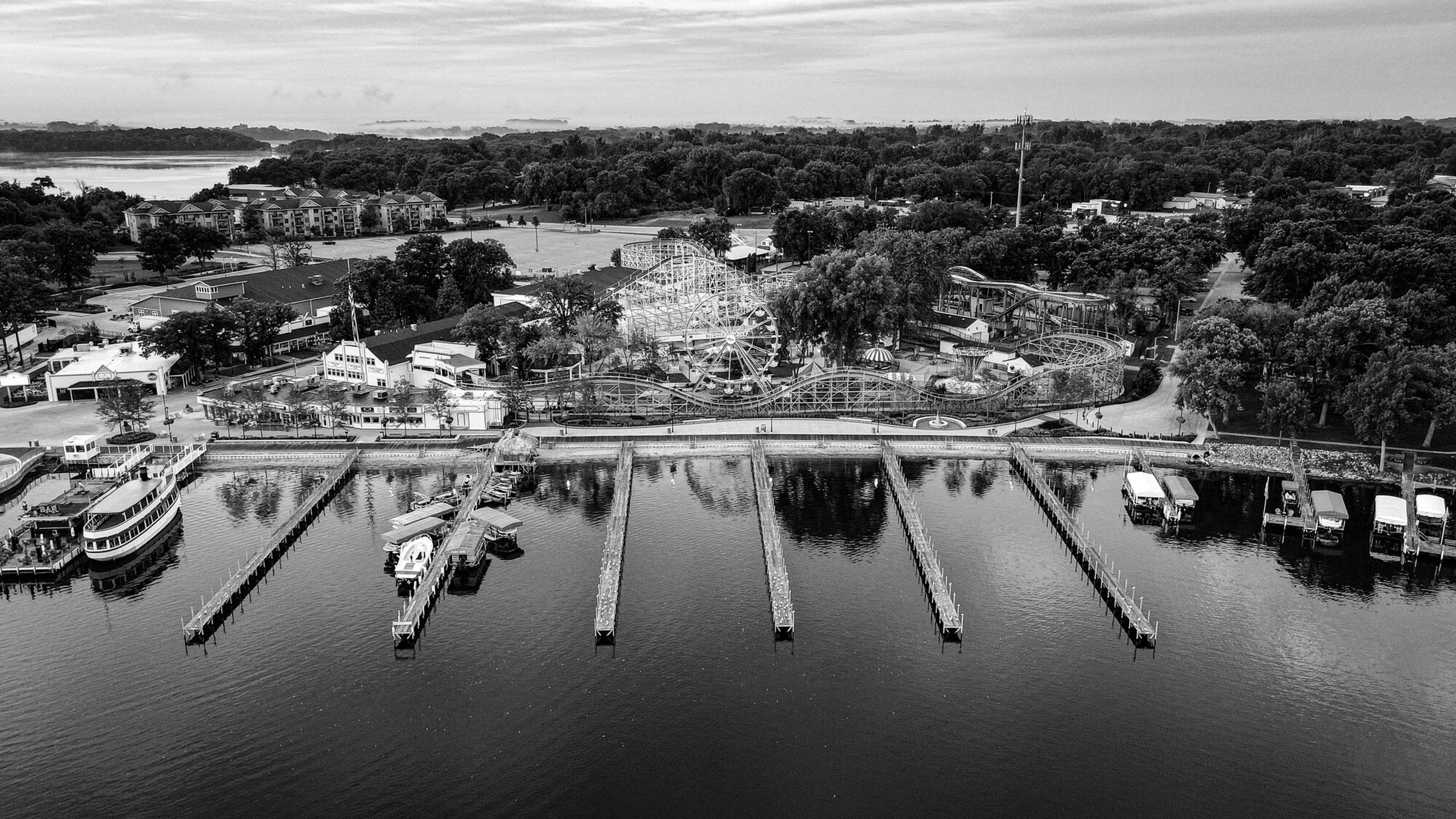 Aerial view of empty boat docks reaching into a still lake, in black and white
