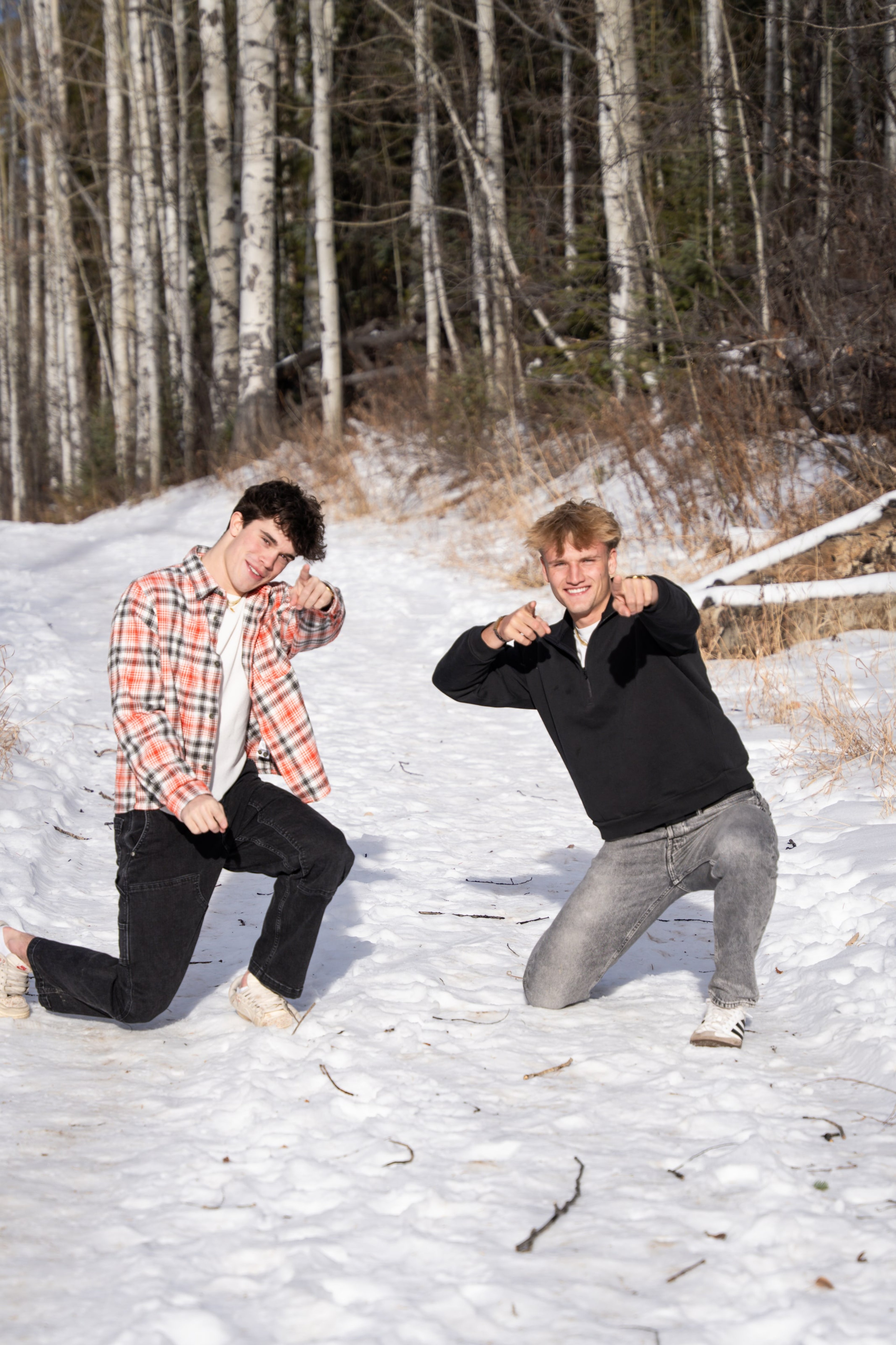 Jakob and Ryder kneeling and flexing in the snow