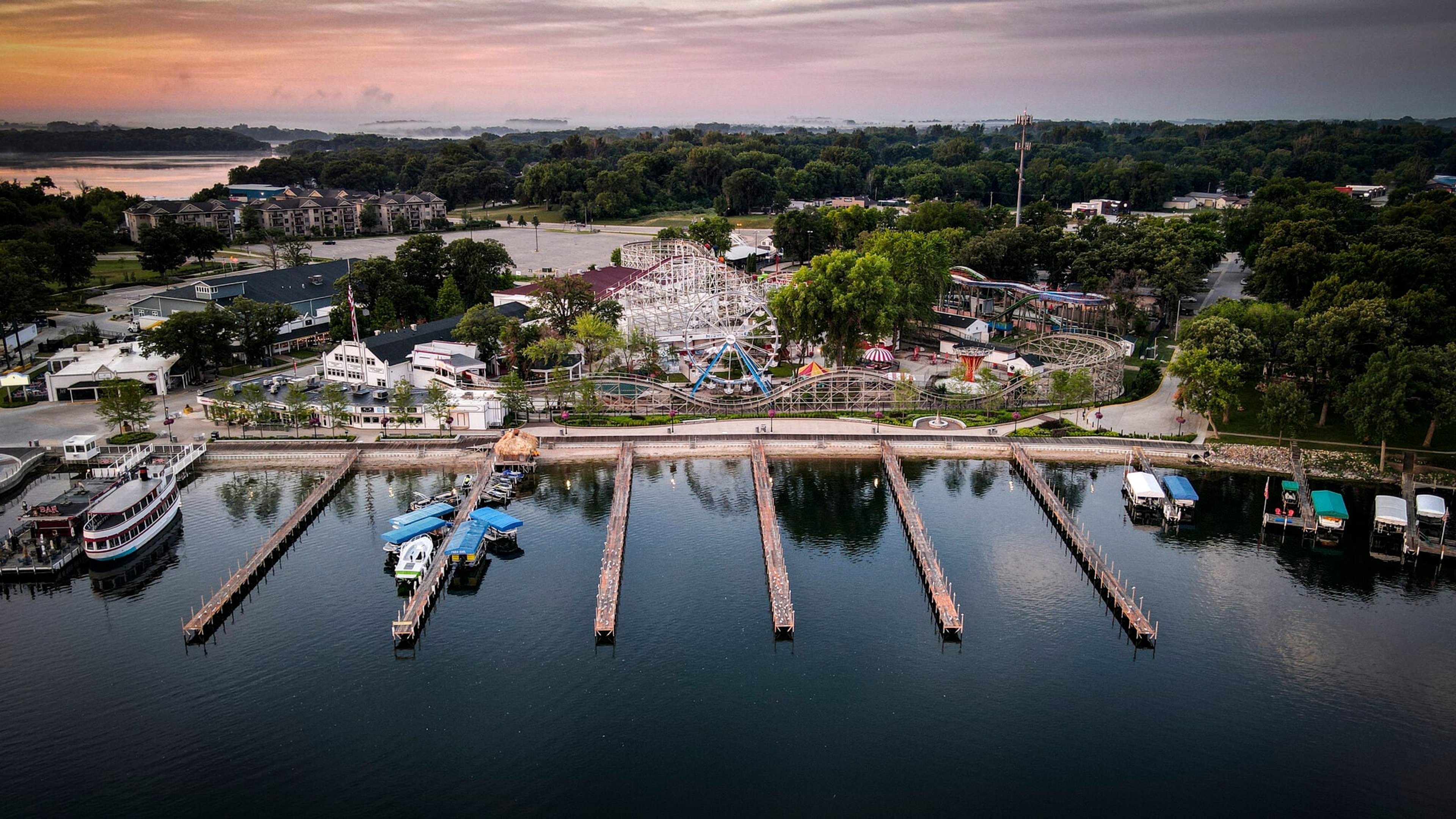 Aerial of lakeside docks at dusk, pink sky on still water, Iowa