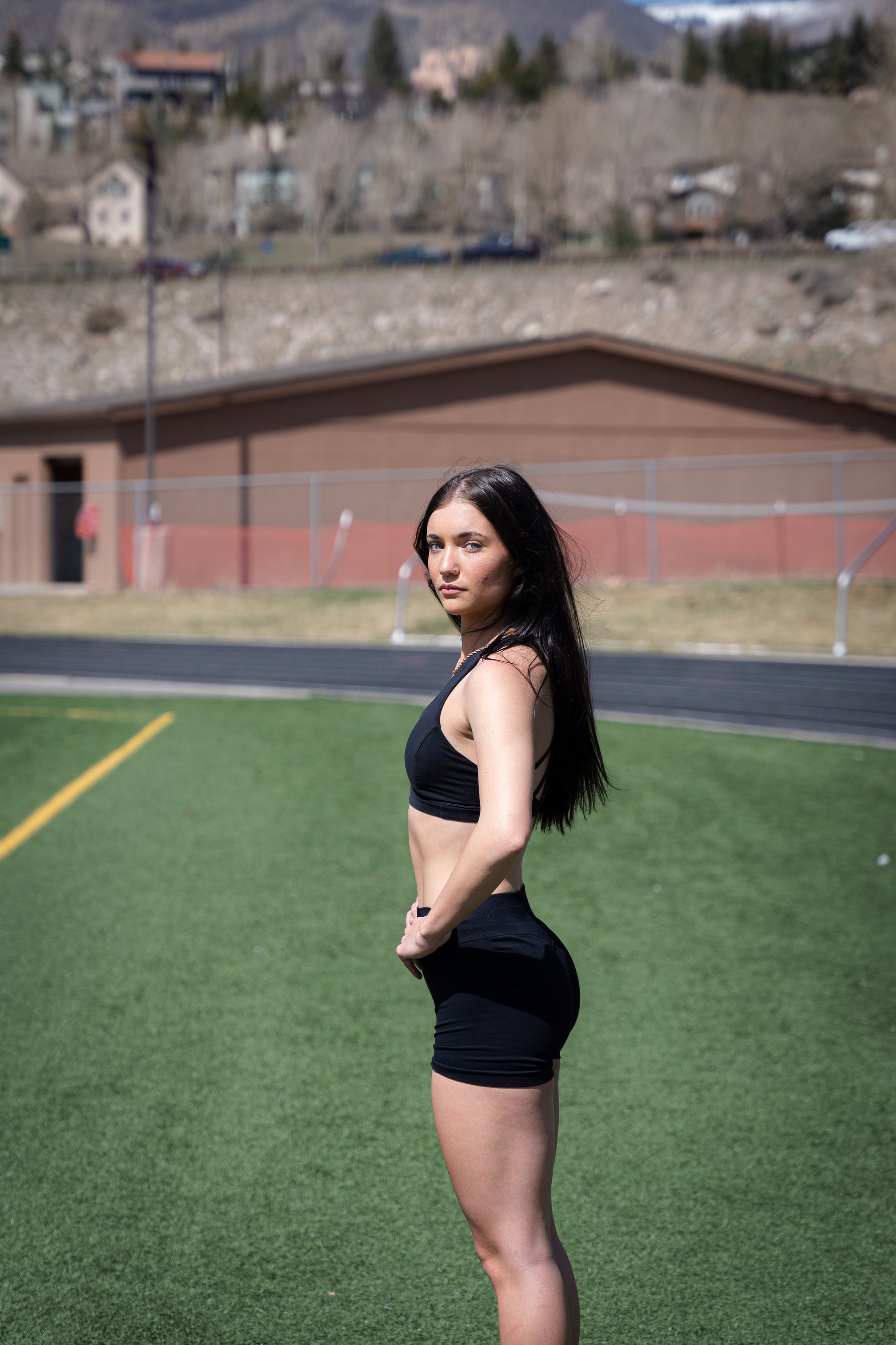 Lucy standing on the pitch, goalposts and ridge behind