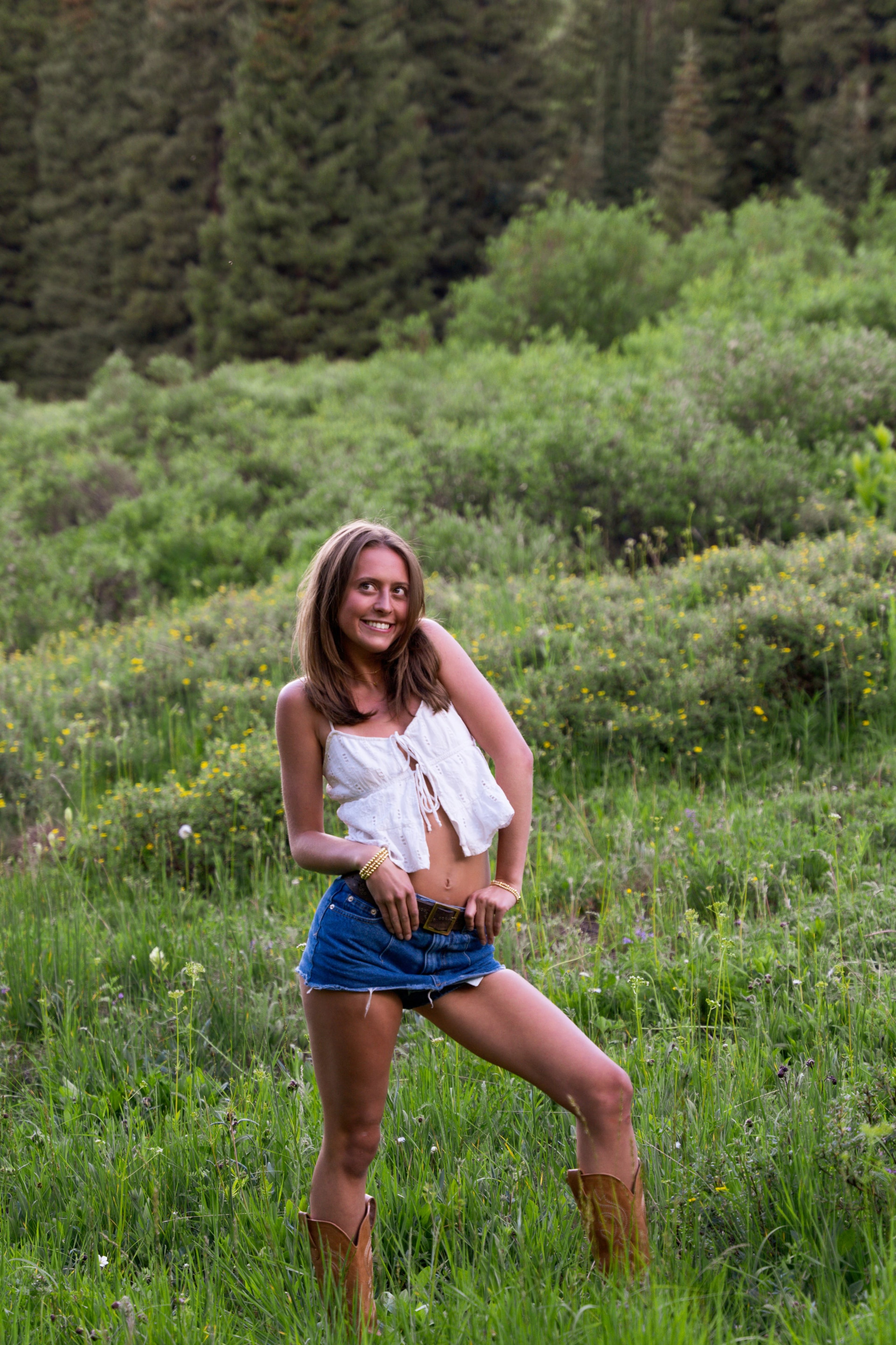 Two friends leaning close in the tall grass, laughing