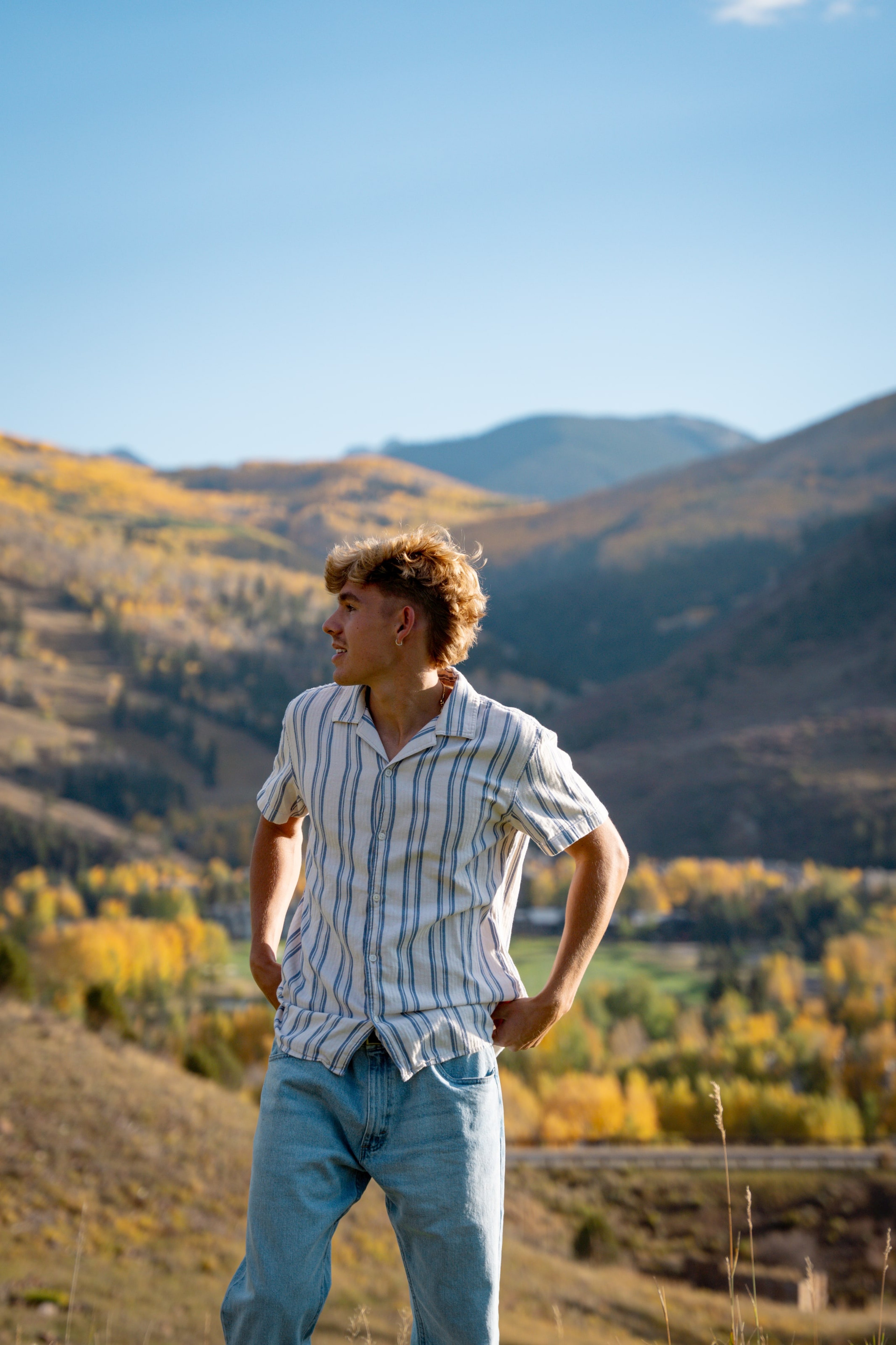 Wyat in a striped shirt looking across the autumn hills