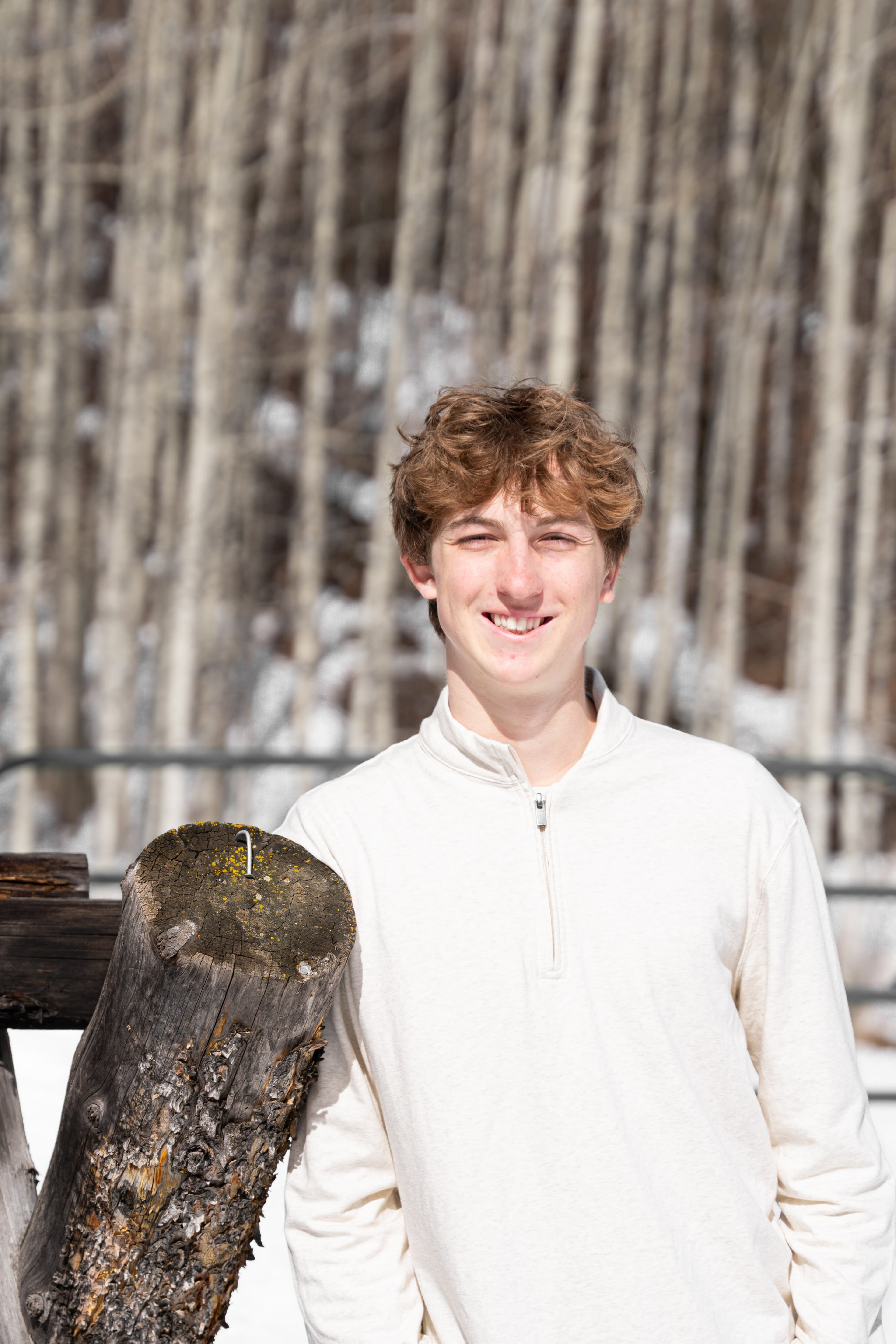 Wake holding a weathered fence log, smiling