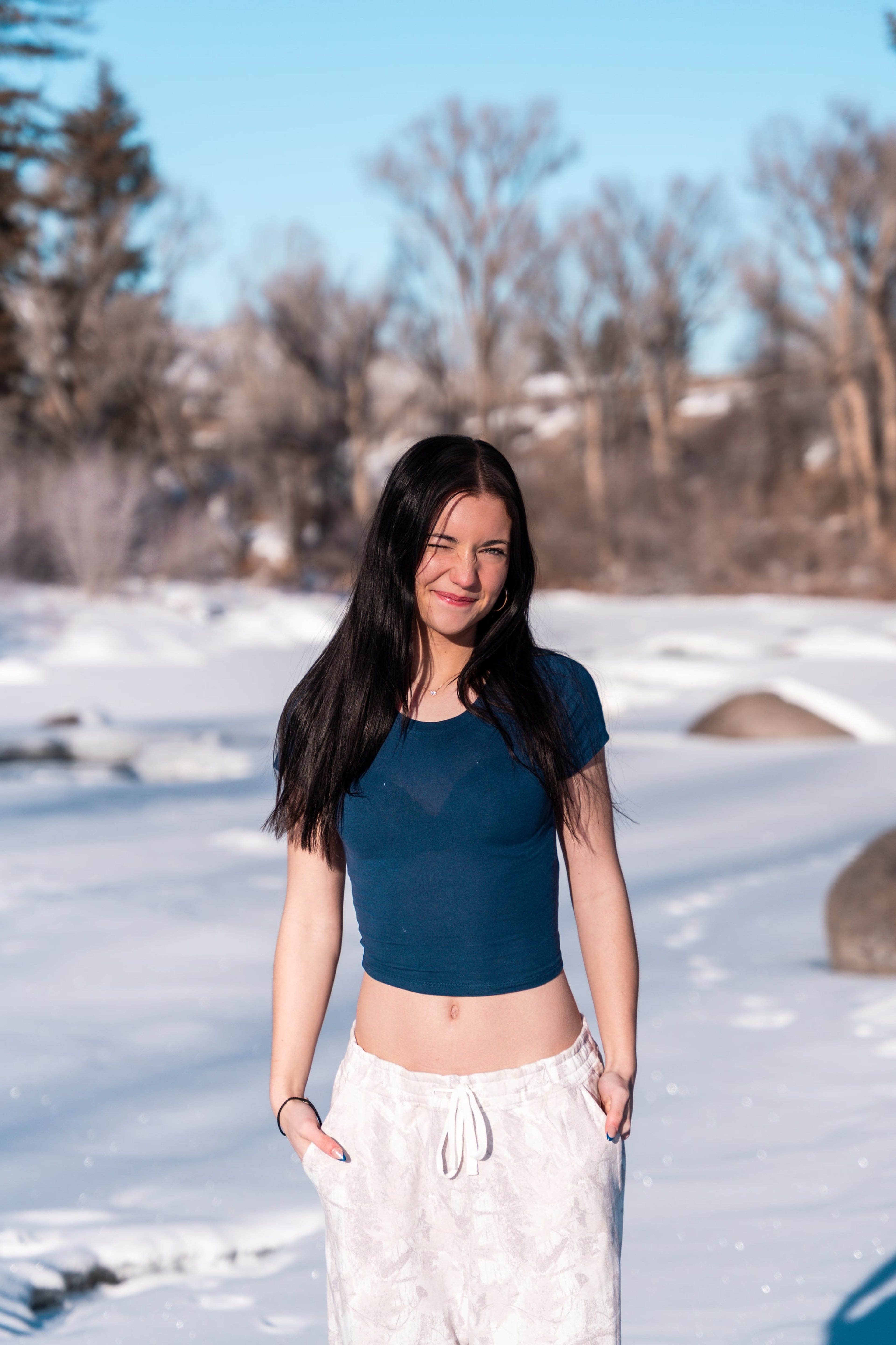 Lucy walking the snowy bank smiling, hands loose
