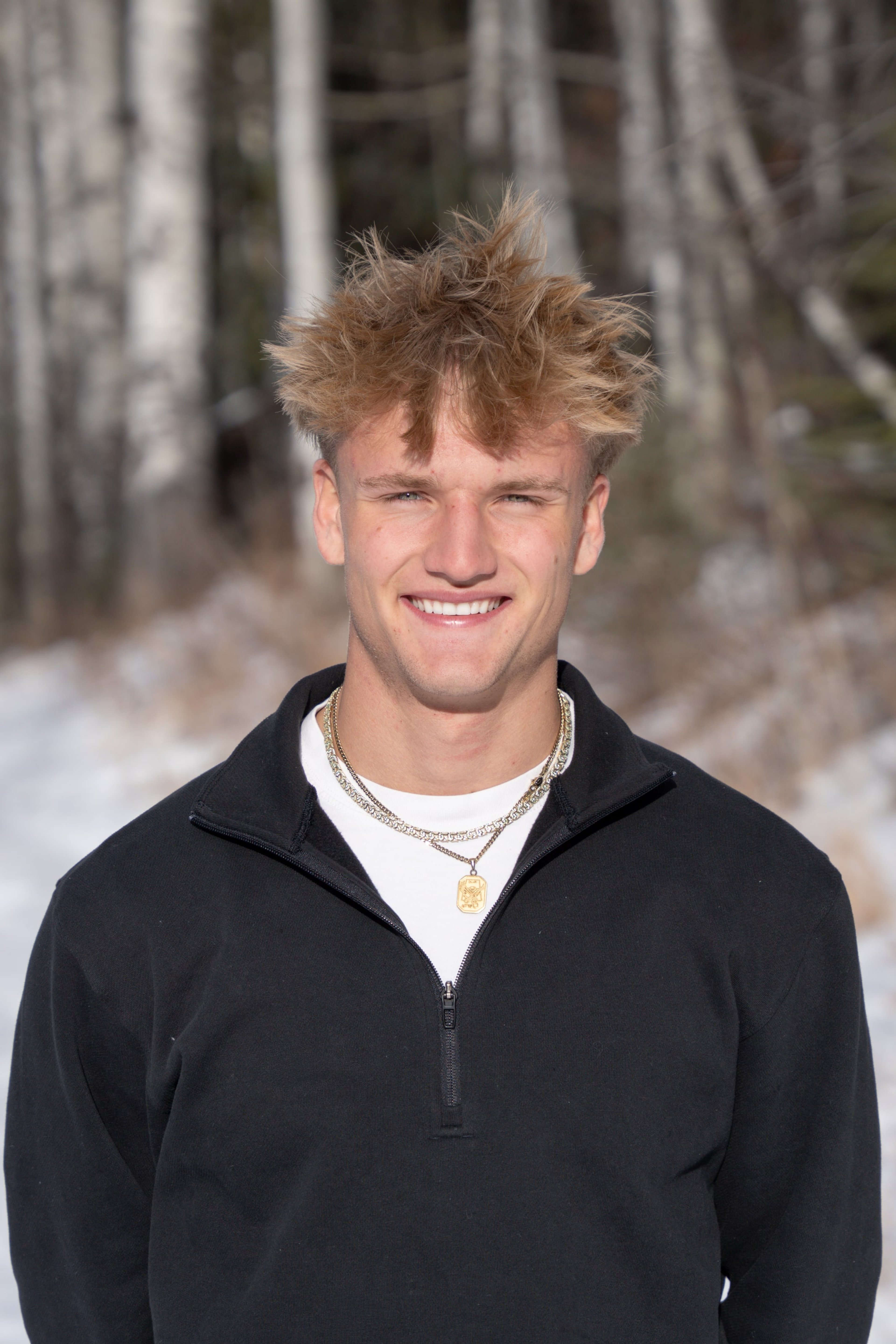 Close portrait of Jakob in black against the snow