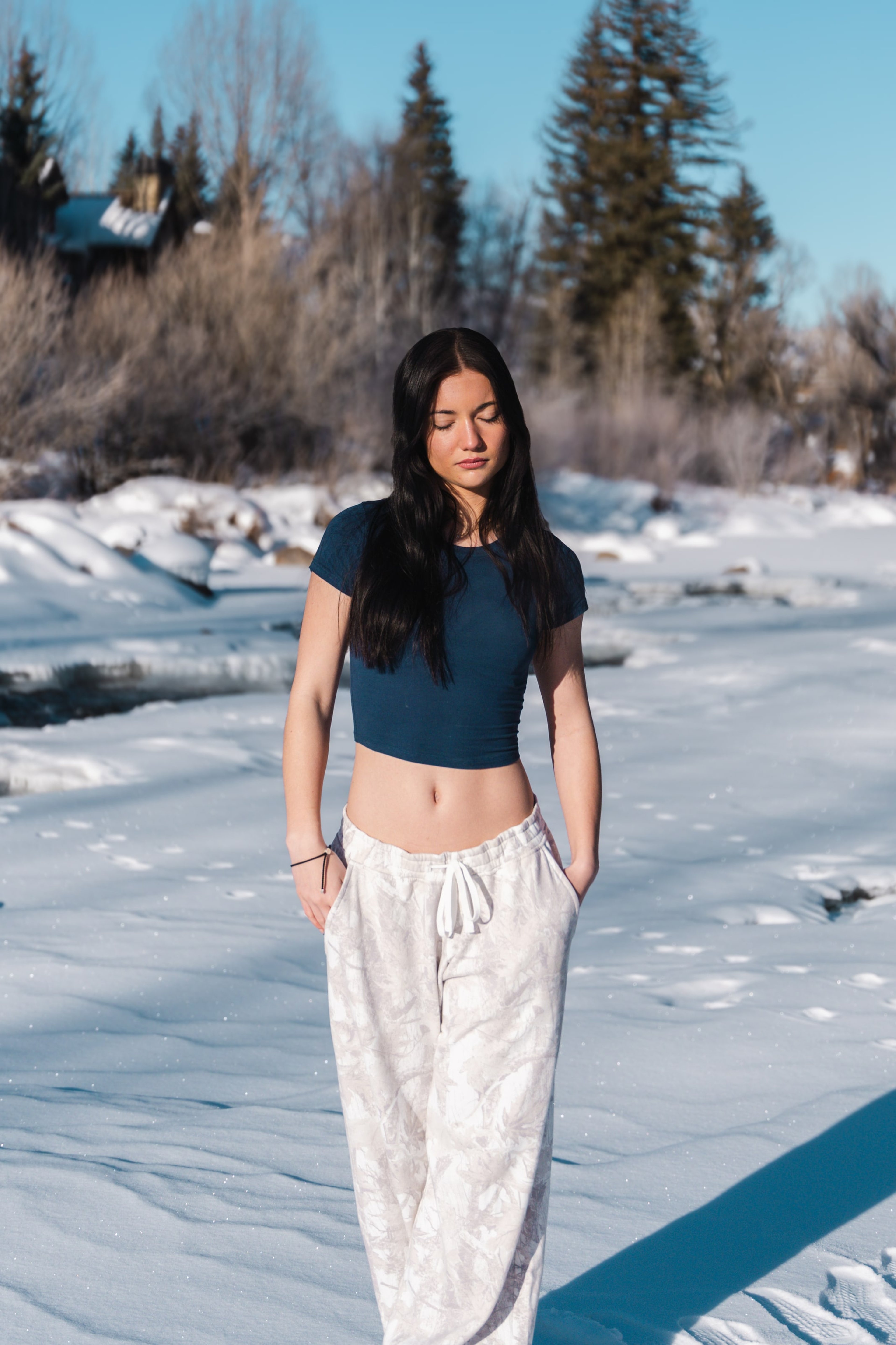 Lucy standing on the frozen river flats, hands in her skirt pockets