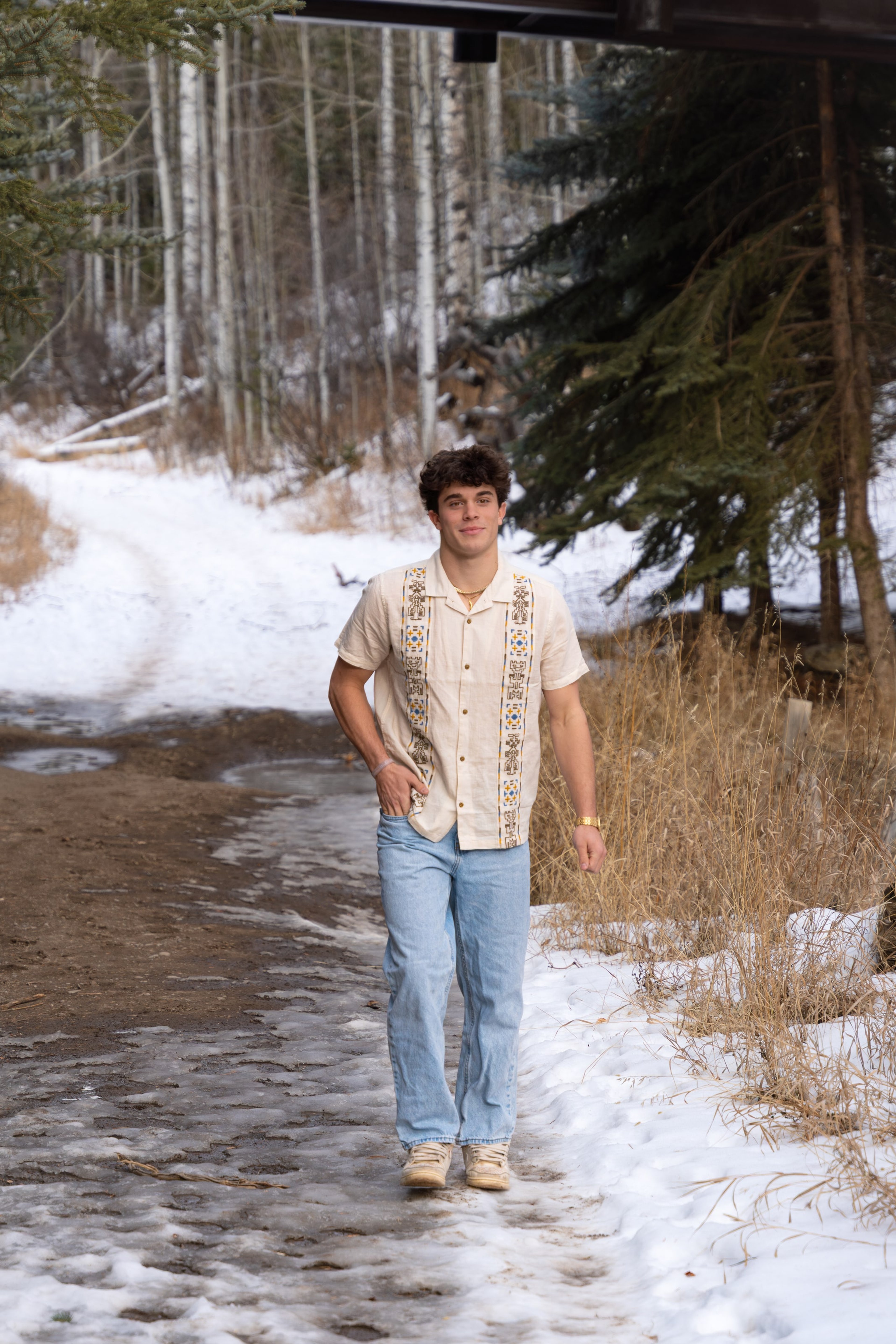 Ryder walking a muddy spring path between snowbanks