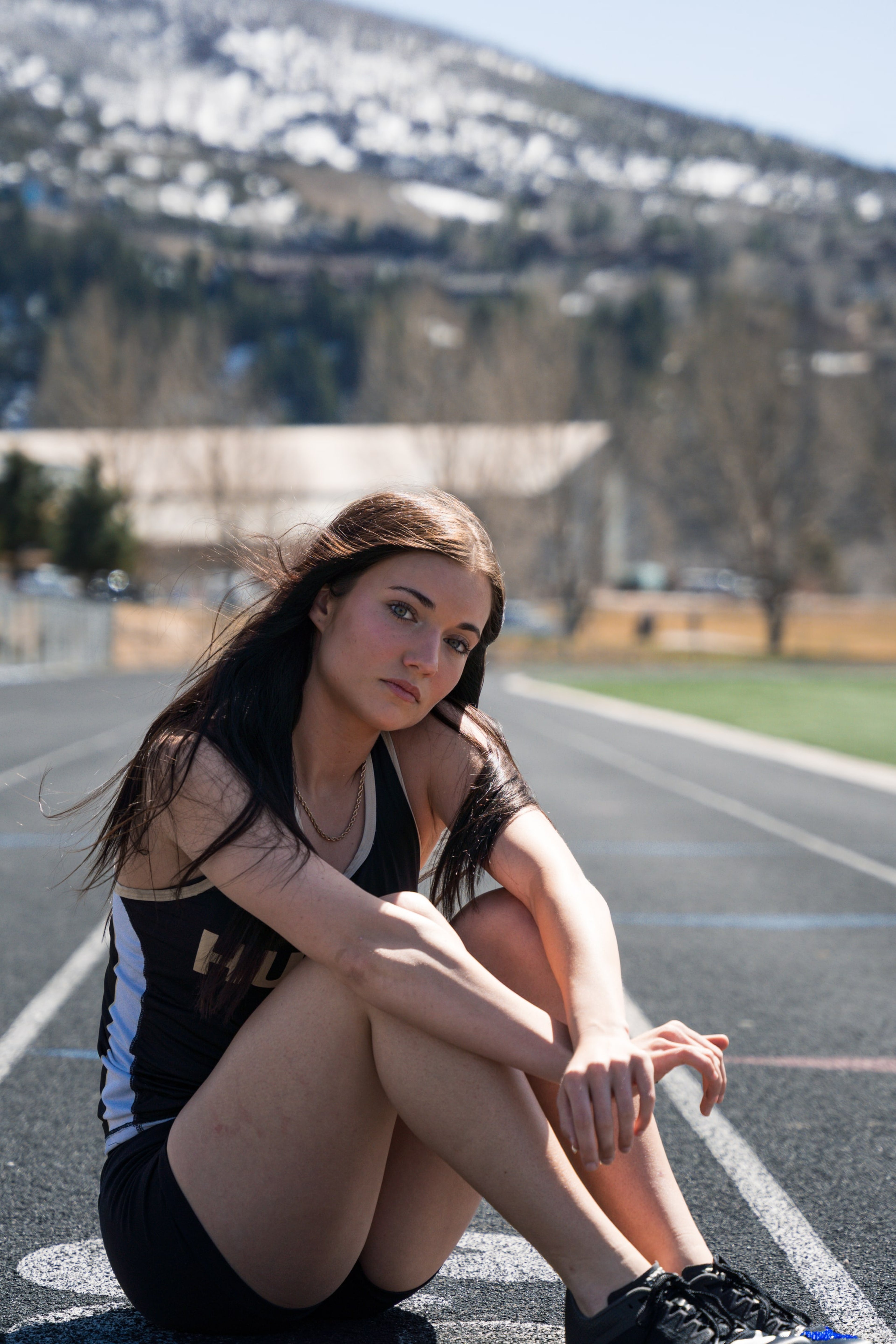 Lucy seated on the lane lines, knee up, quiet
