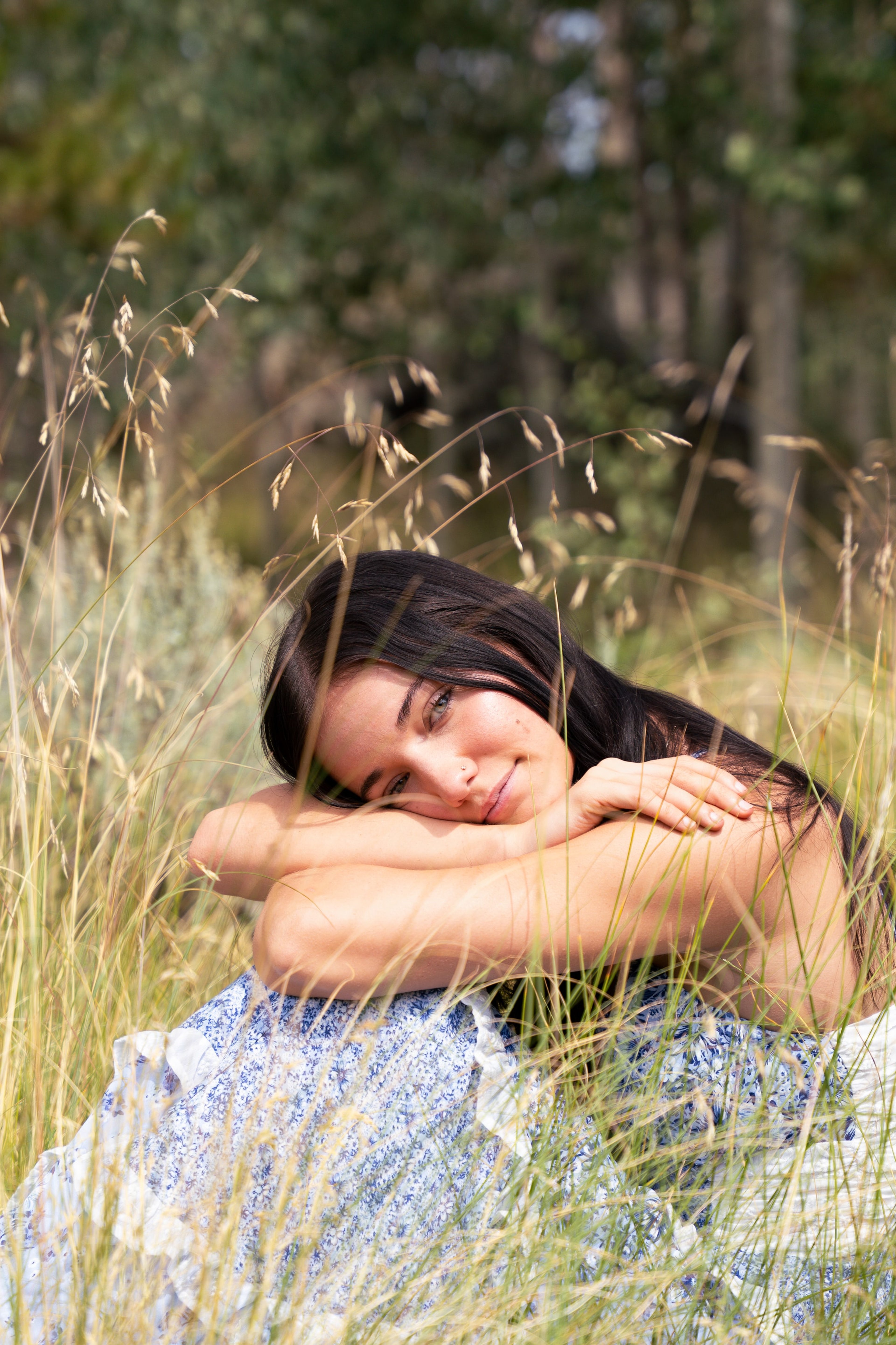 Lucy lying back on a river rock in tall grass, eyes closed