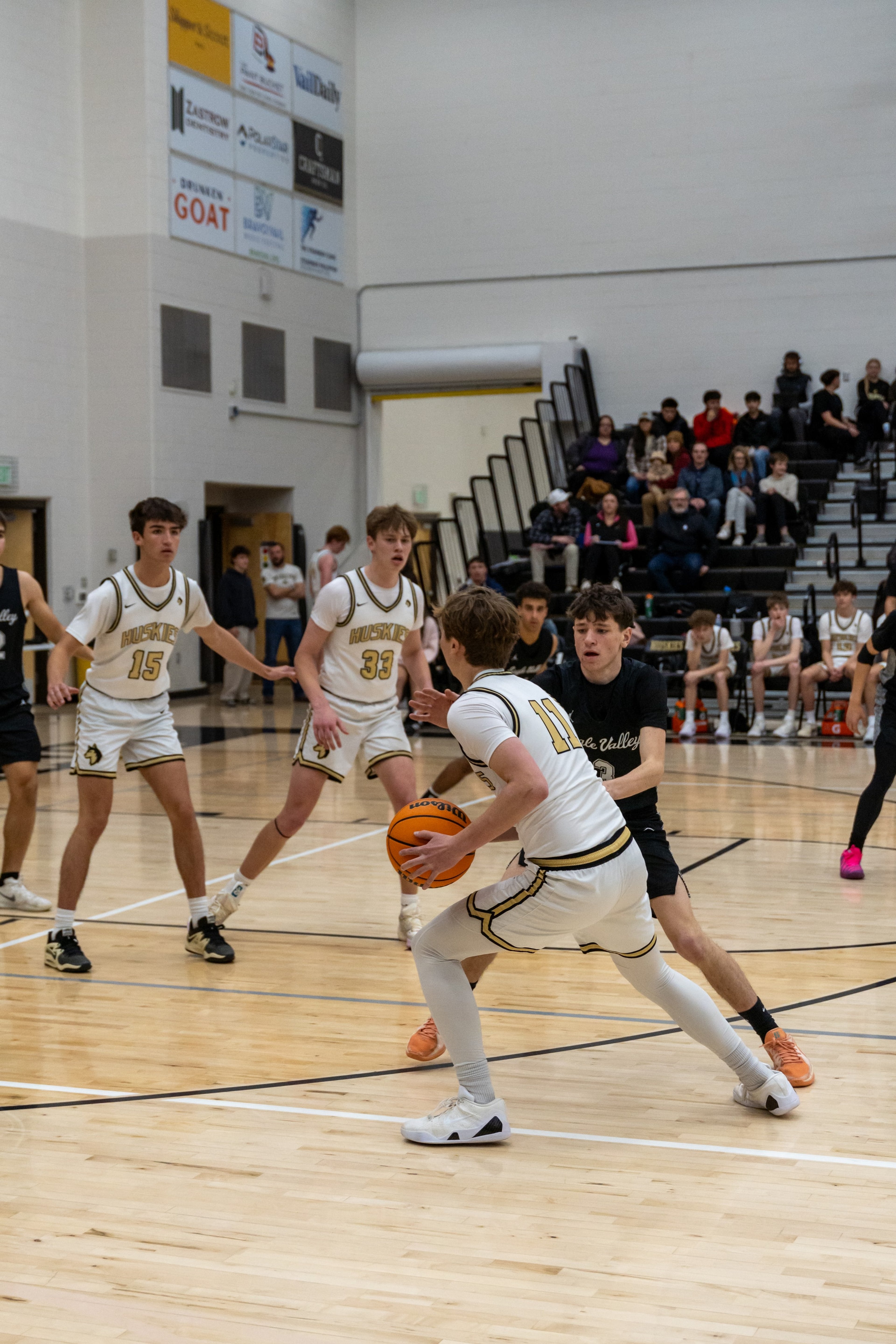 A guard gathers the ball as teammates watch from across the lane