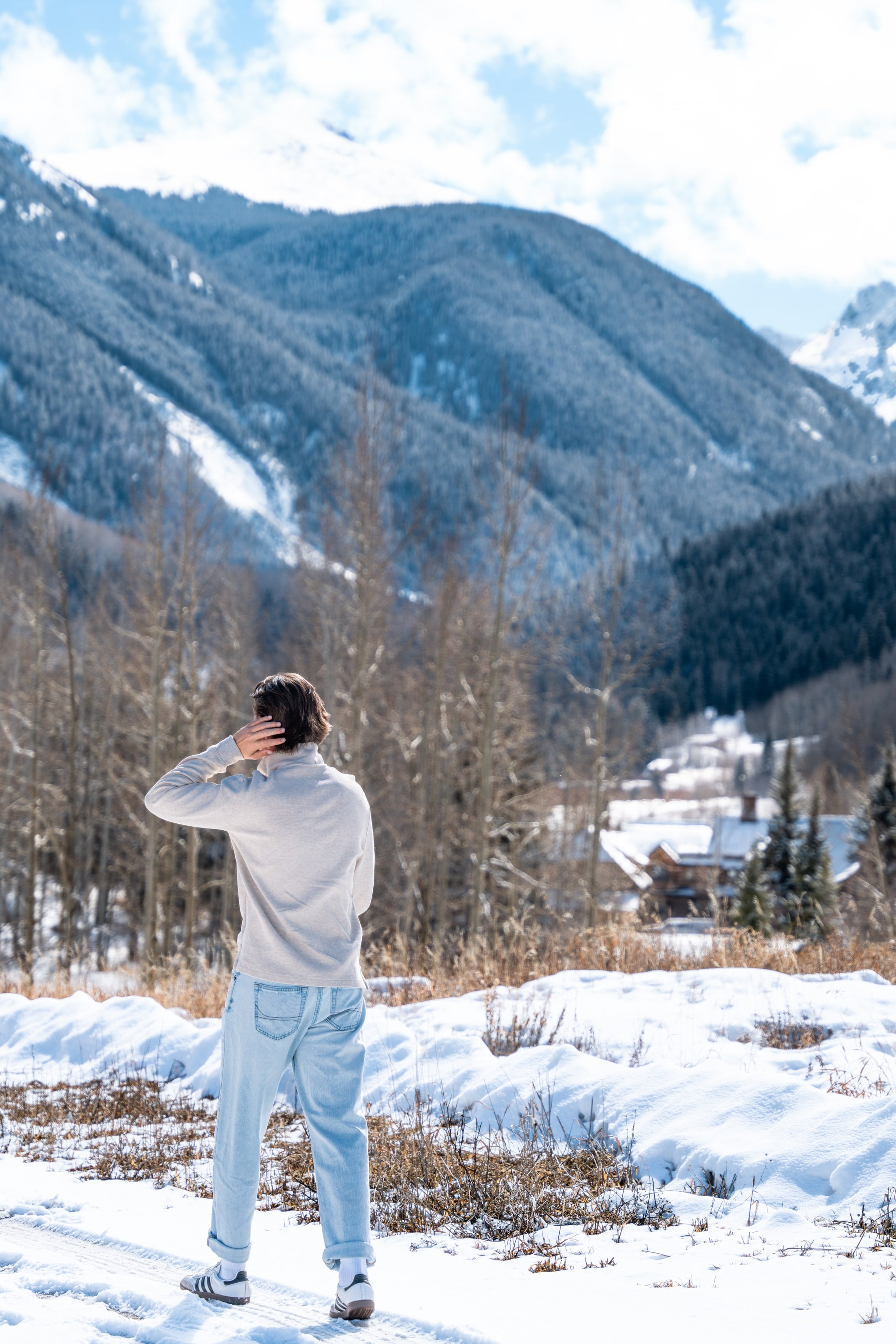 Caeden shielding his eyes toward the snowy valley, back to the camera