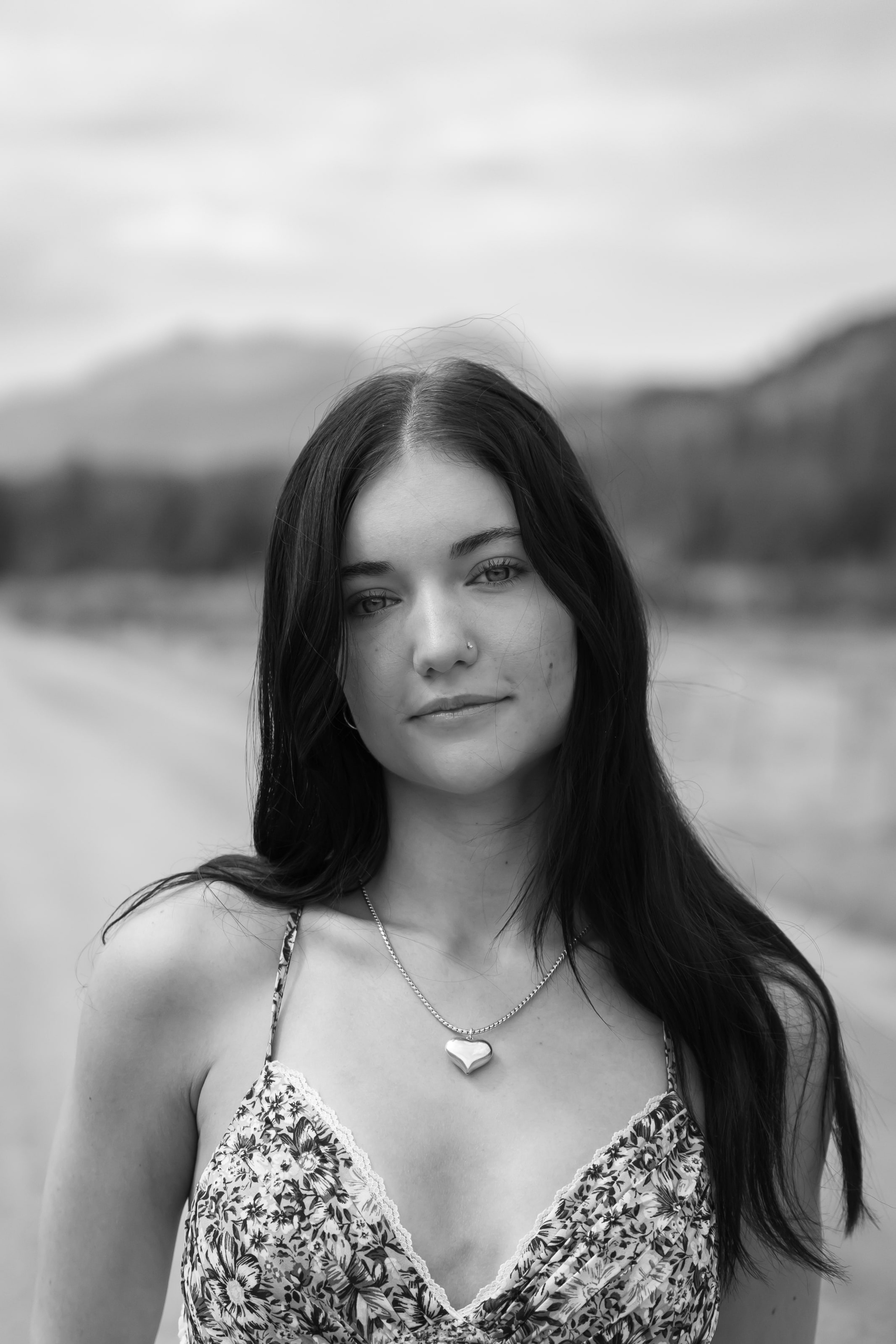 Close black-and-white portrait of Lucy, hair down, lake light behind
