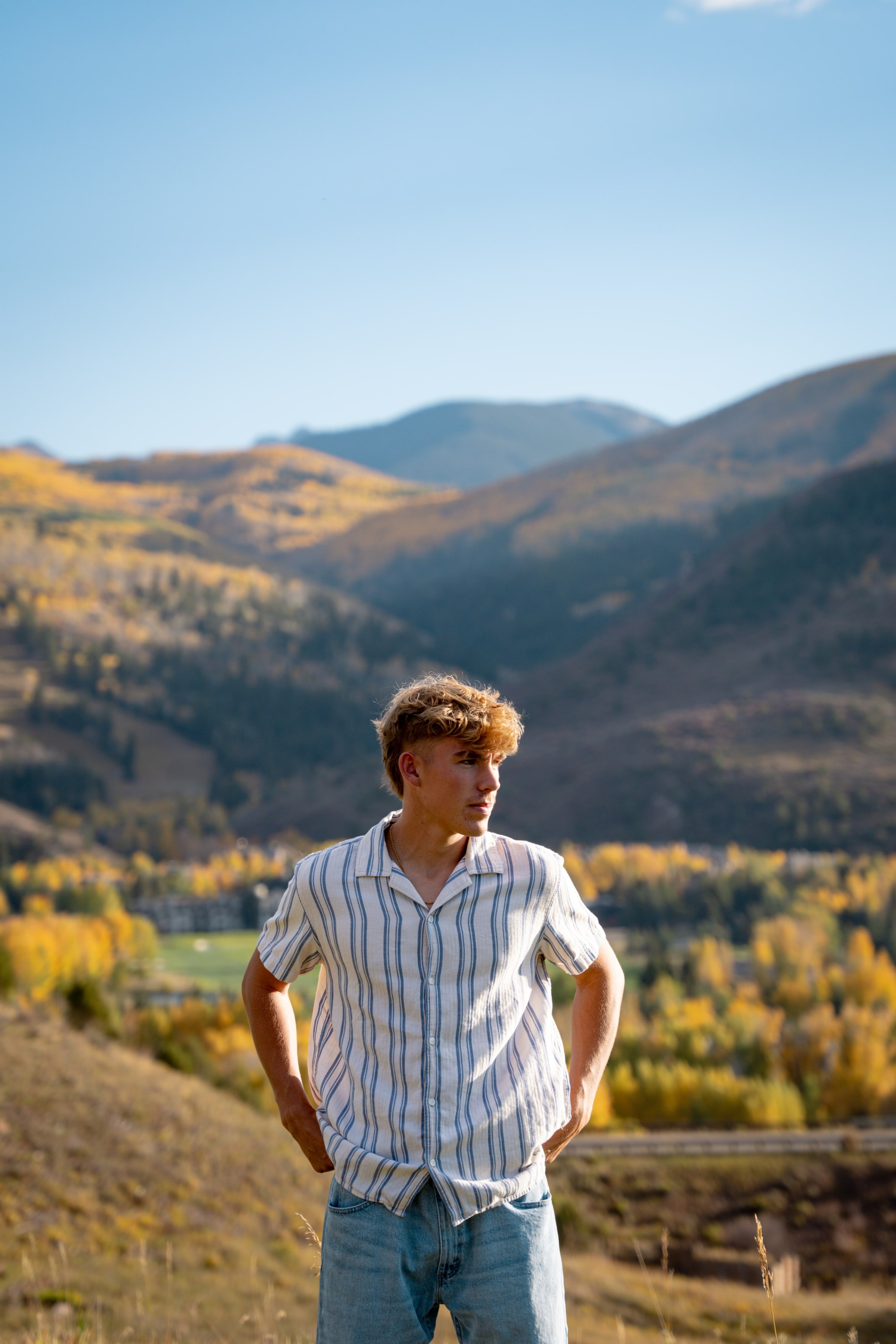 Wyat standing above the valley, hands on hips, hills rolling gold