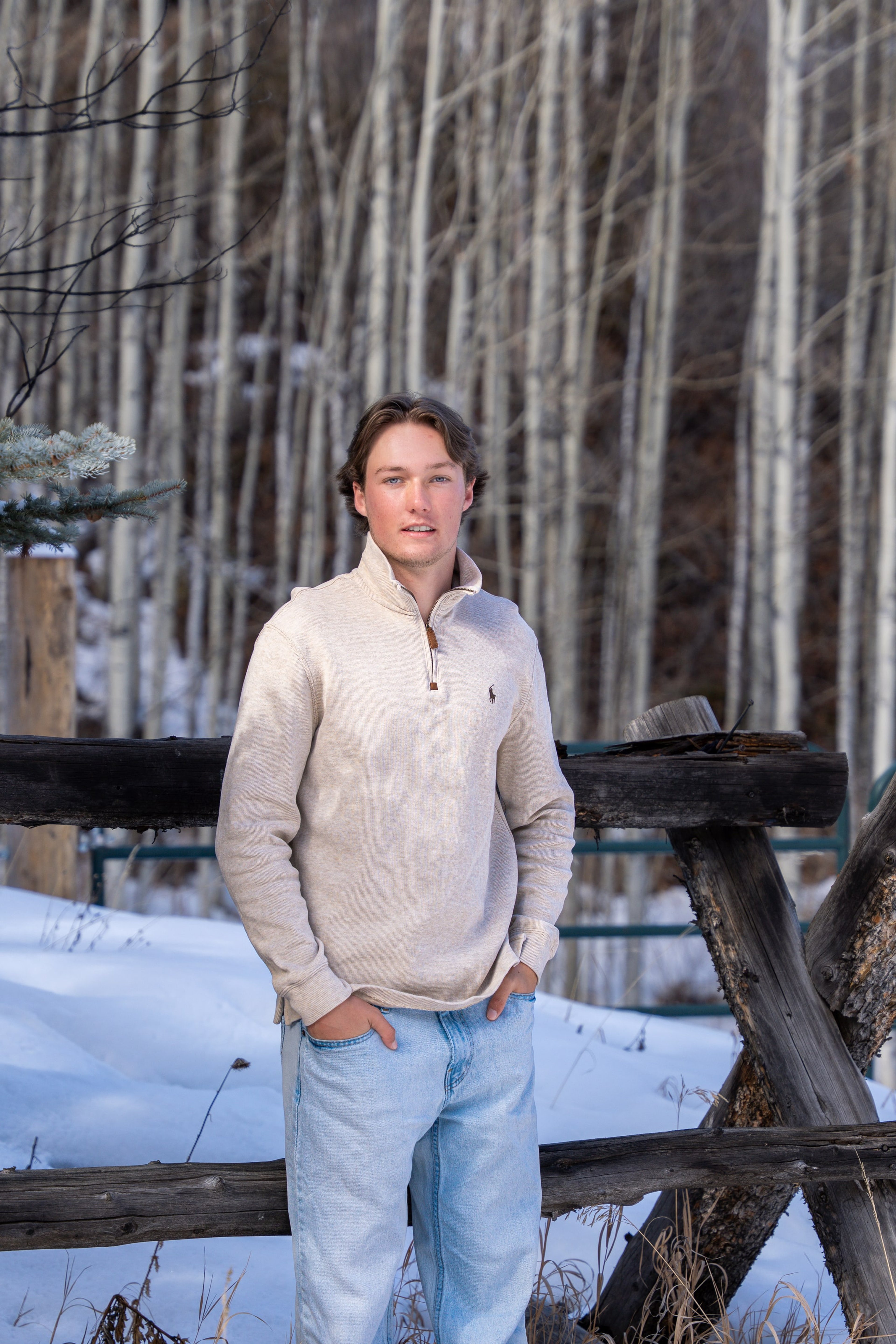 Caeden leaning on a buck-rail fence, hands in pockets