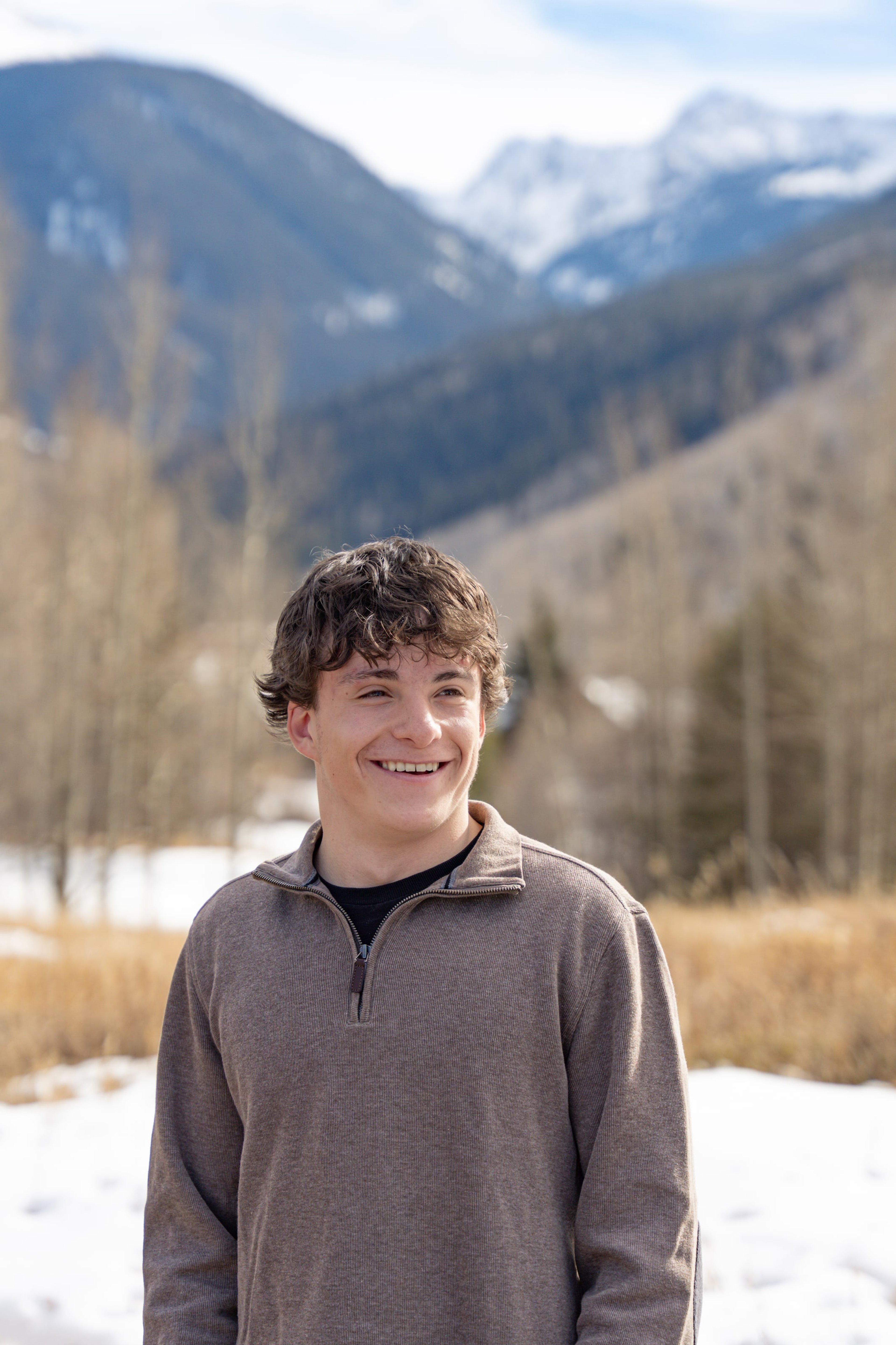 Luca smiling in the aspen grove, mountains soft behind