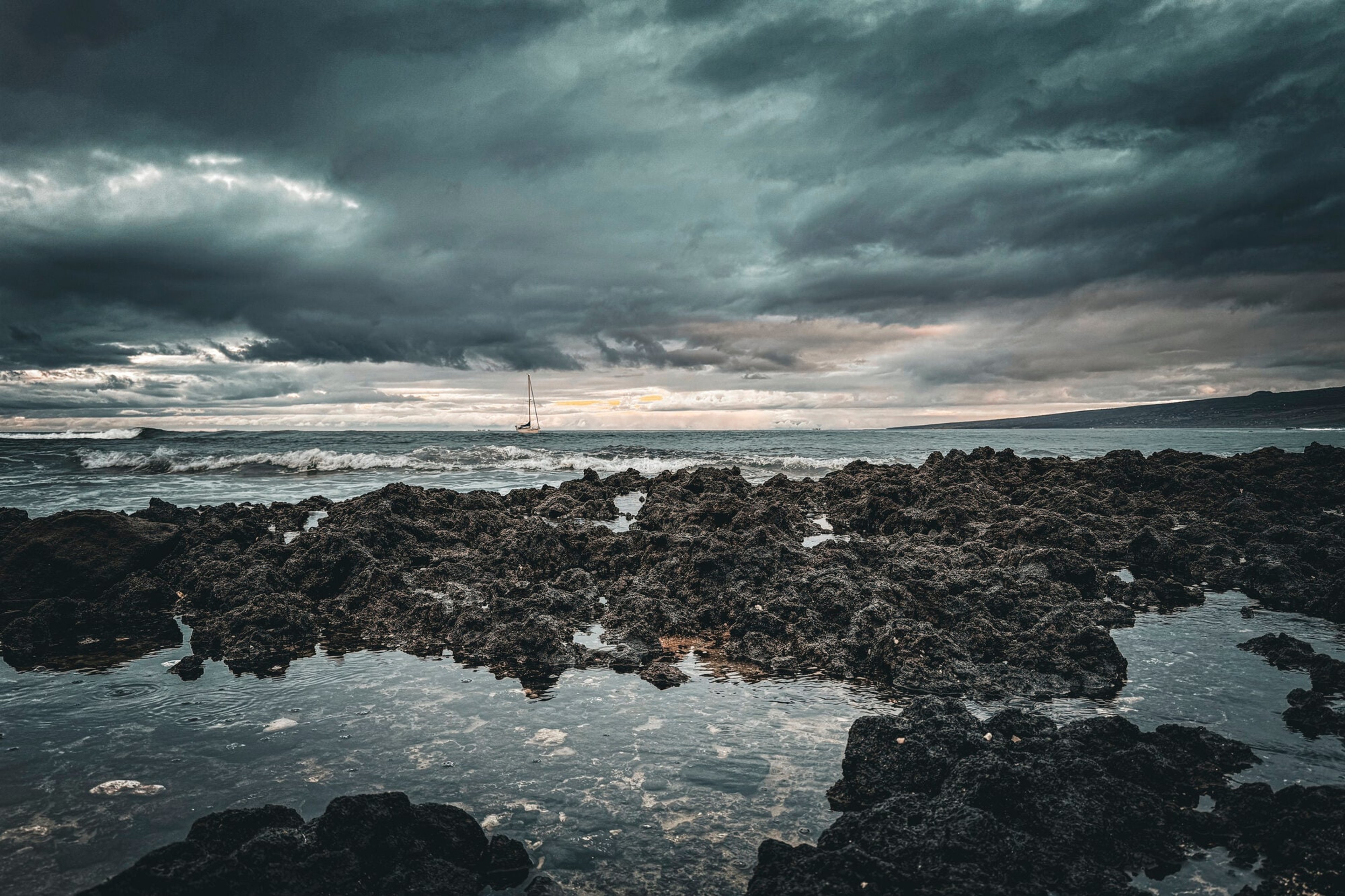 Storm light over dark lava tidepools on the Hawaiian coast